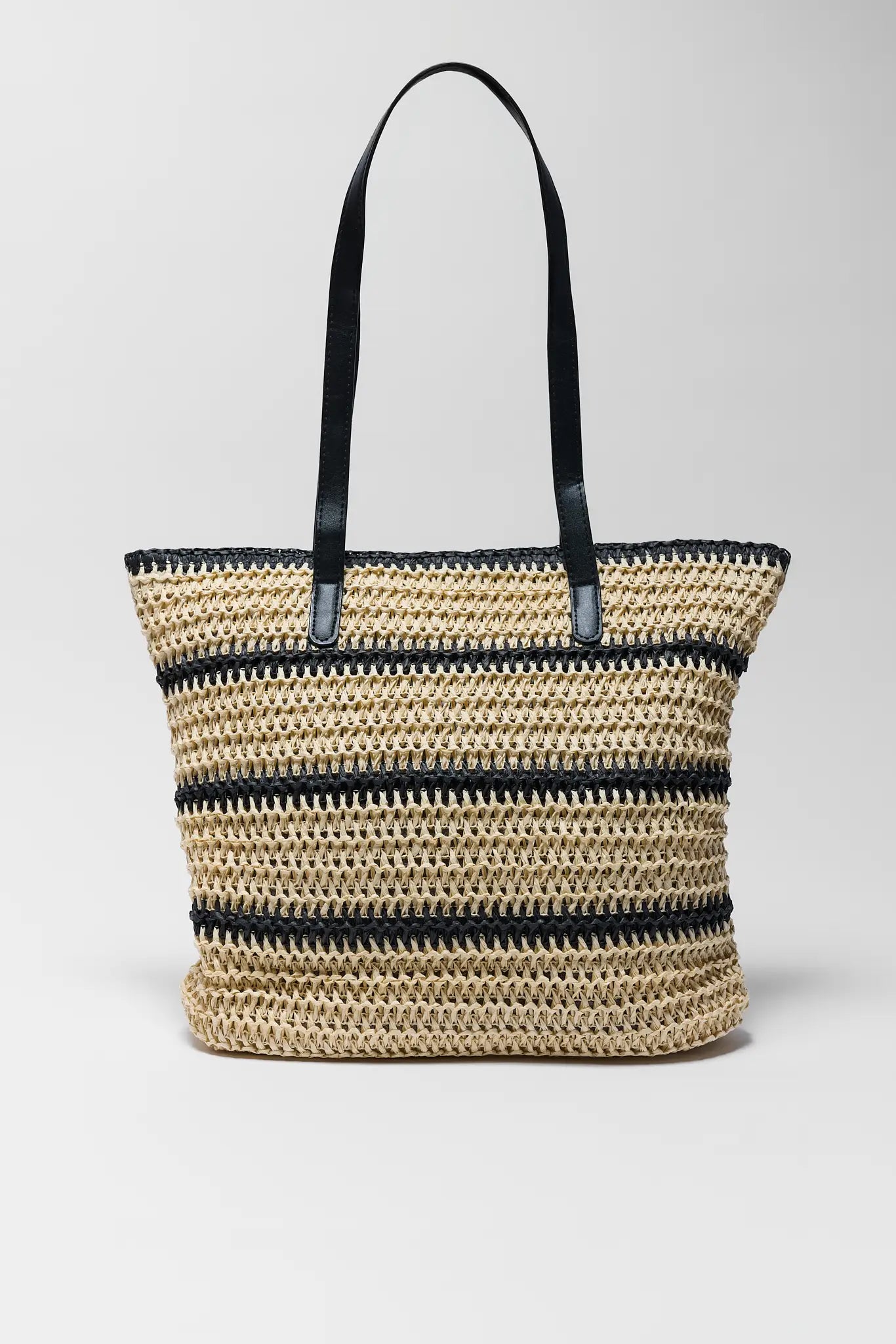 Woven straw tote bag with black accents on a light gray background
