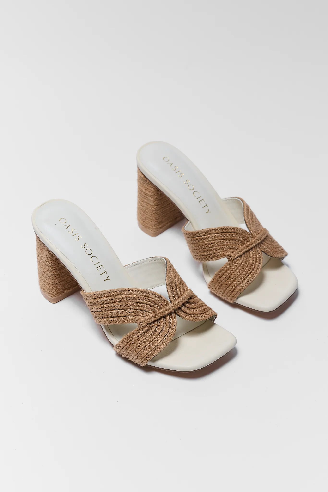 Pair of high-heeled sandals with woven straps on a white background