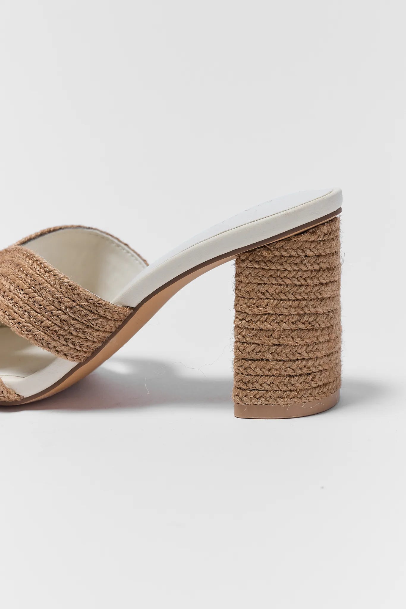 Beige sandal with woven heel on a white background