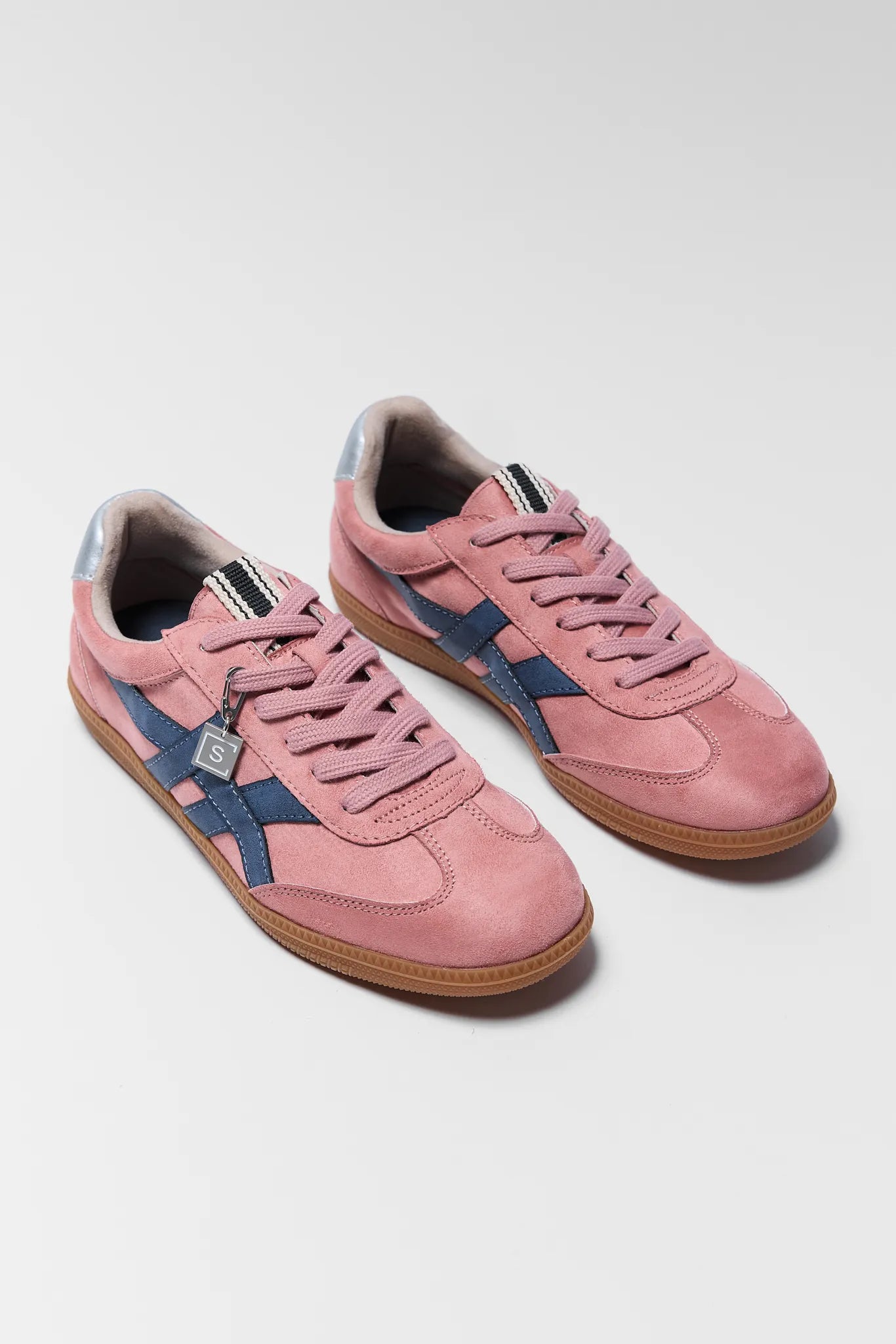 two pink sneakers with navy details on white background