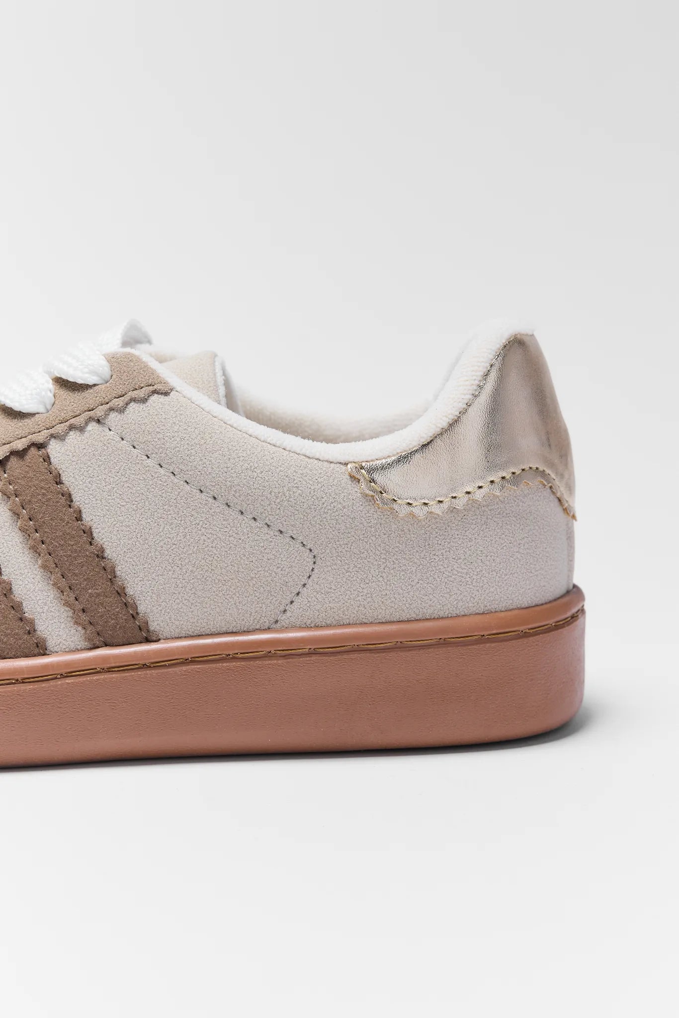 Close-up of a Sylvie Tan Striped Sneakers with a brown sole and beige side panels on a white background