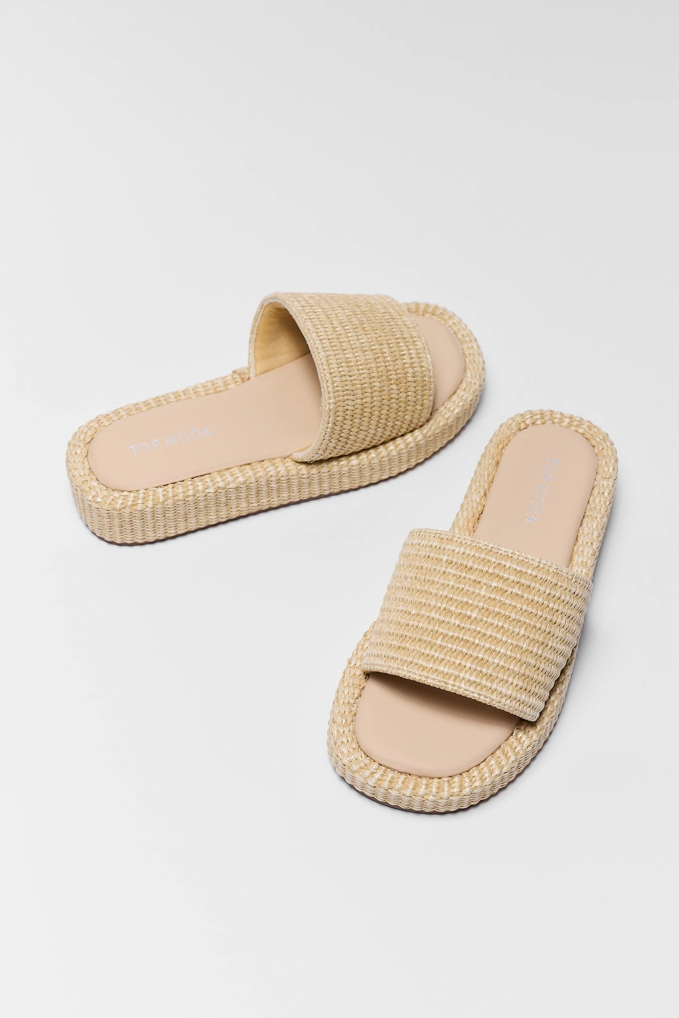 Pair of beige sandals on a light gray background