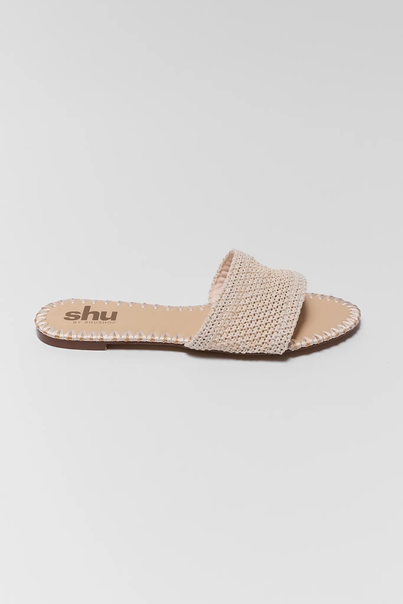 one Beige sandal with woven strap on a light gray background