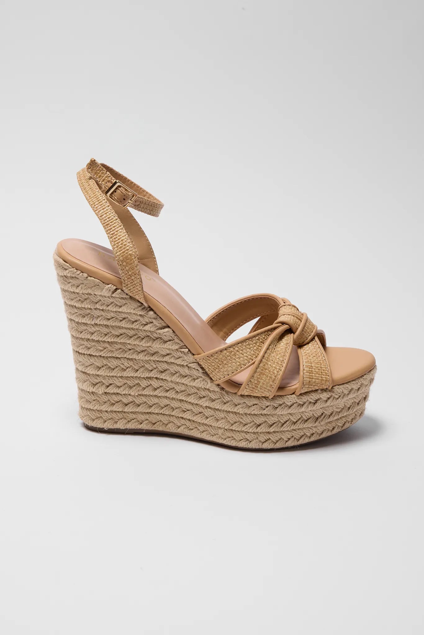 Tan wedge sandal with espadrille sole on a light background