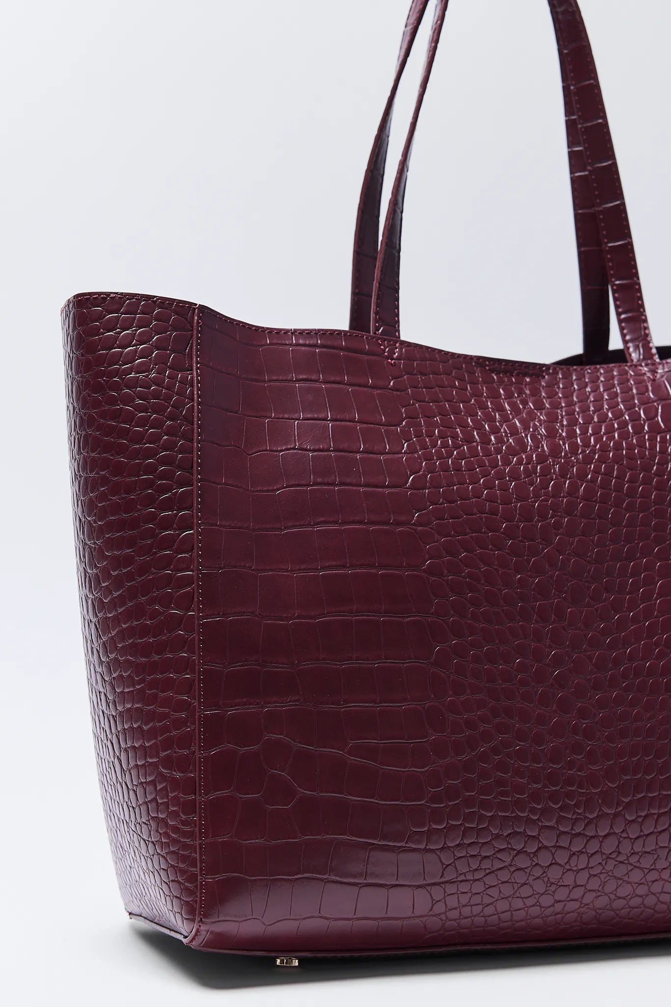 Close-up of a burgundy textured Tiffany Bag on a light gray background
