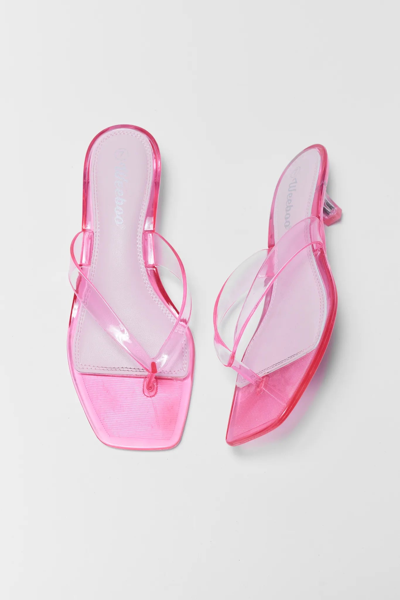 Pink transparent sandals on a light gray background