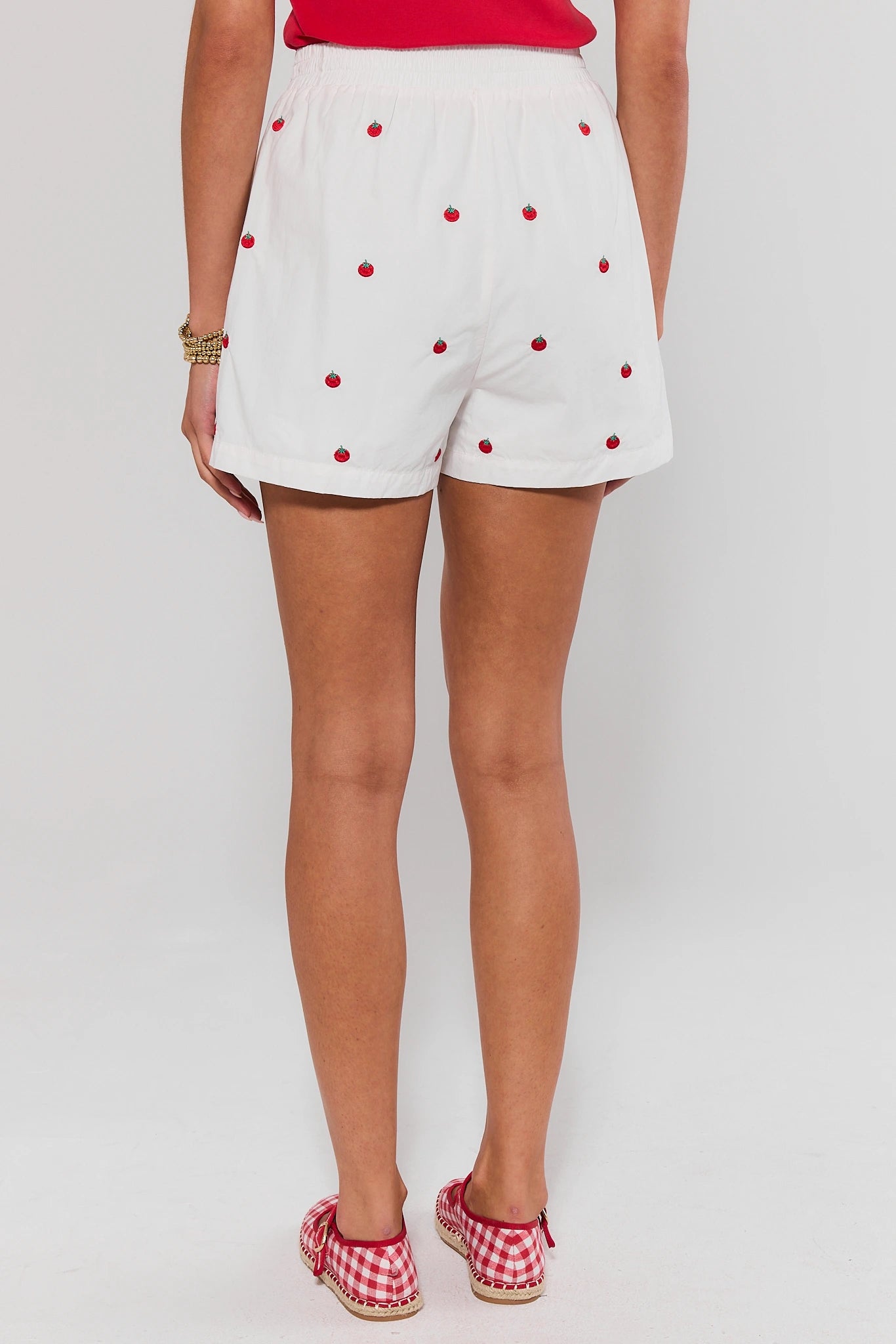 White shorts with red polka dots worn by a woman on a background