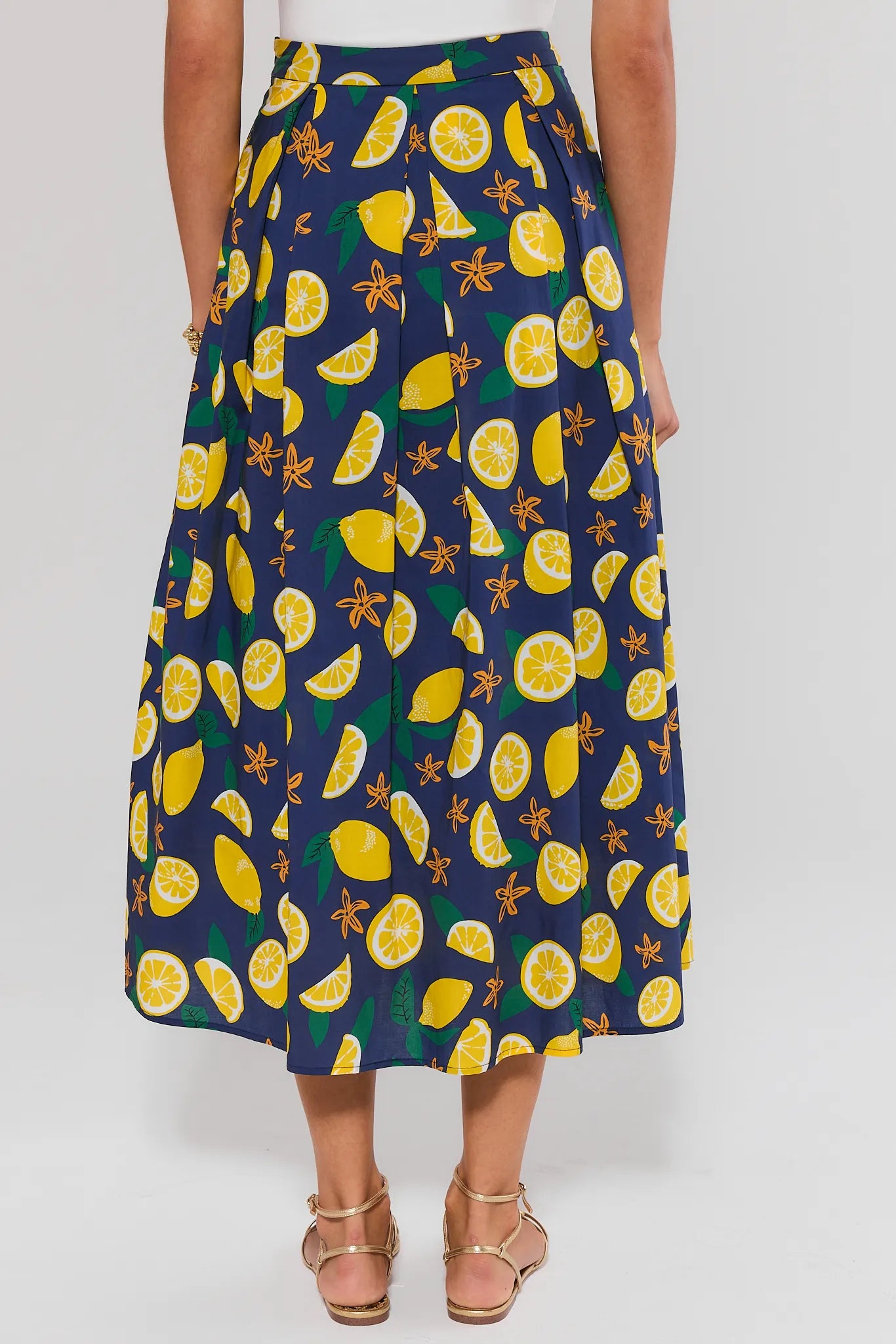 standing Navy blue skirt with yellow lemon pattern worn by a person on a white background