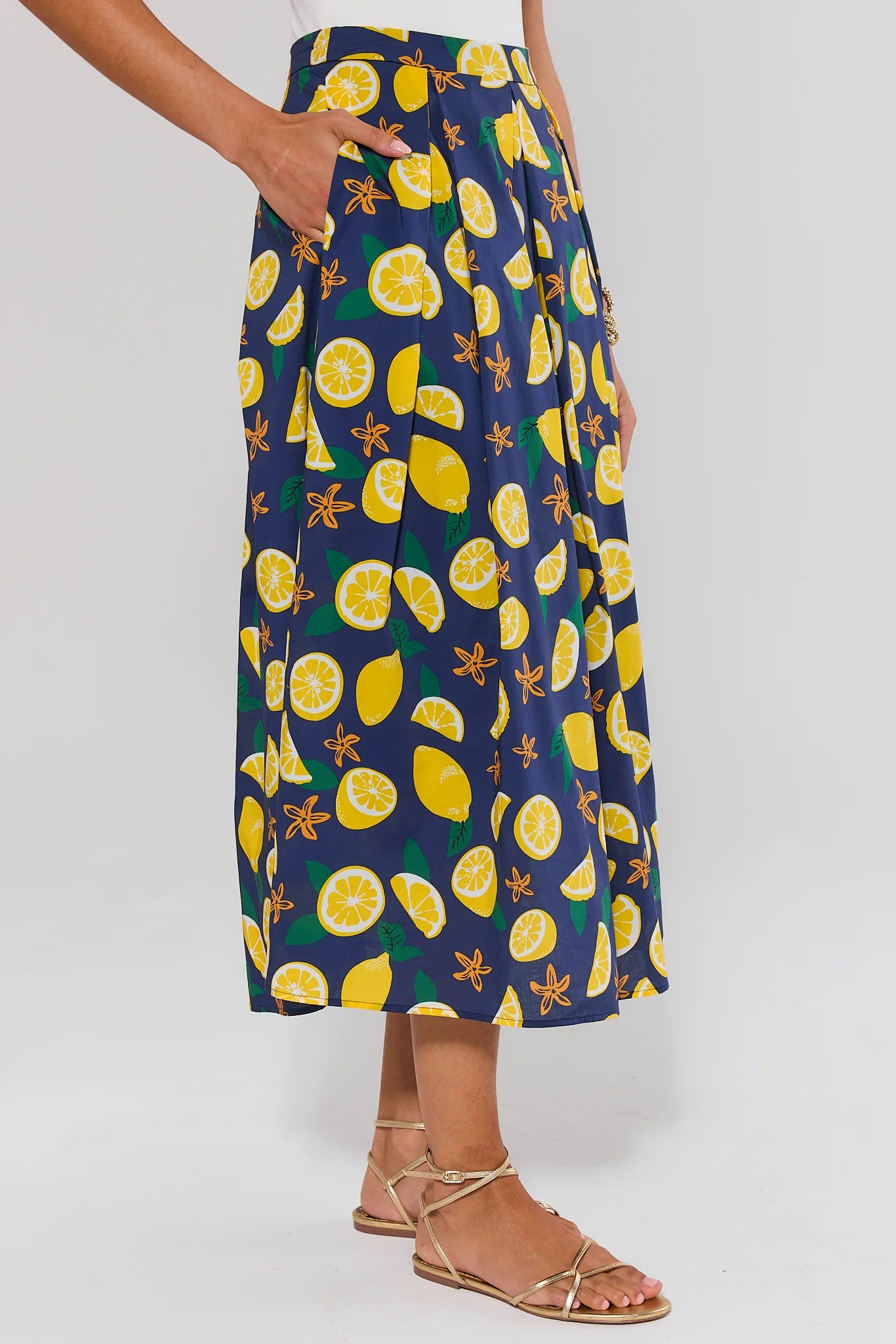 side shot Person wearing a navy blue skirt with yellow lemon pattern on a white background
