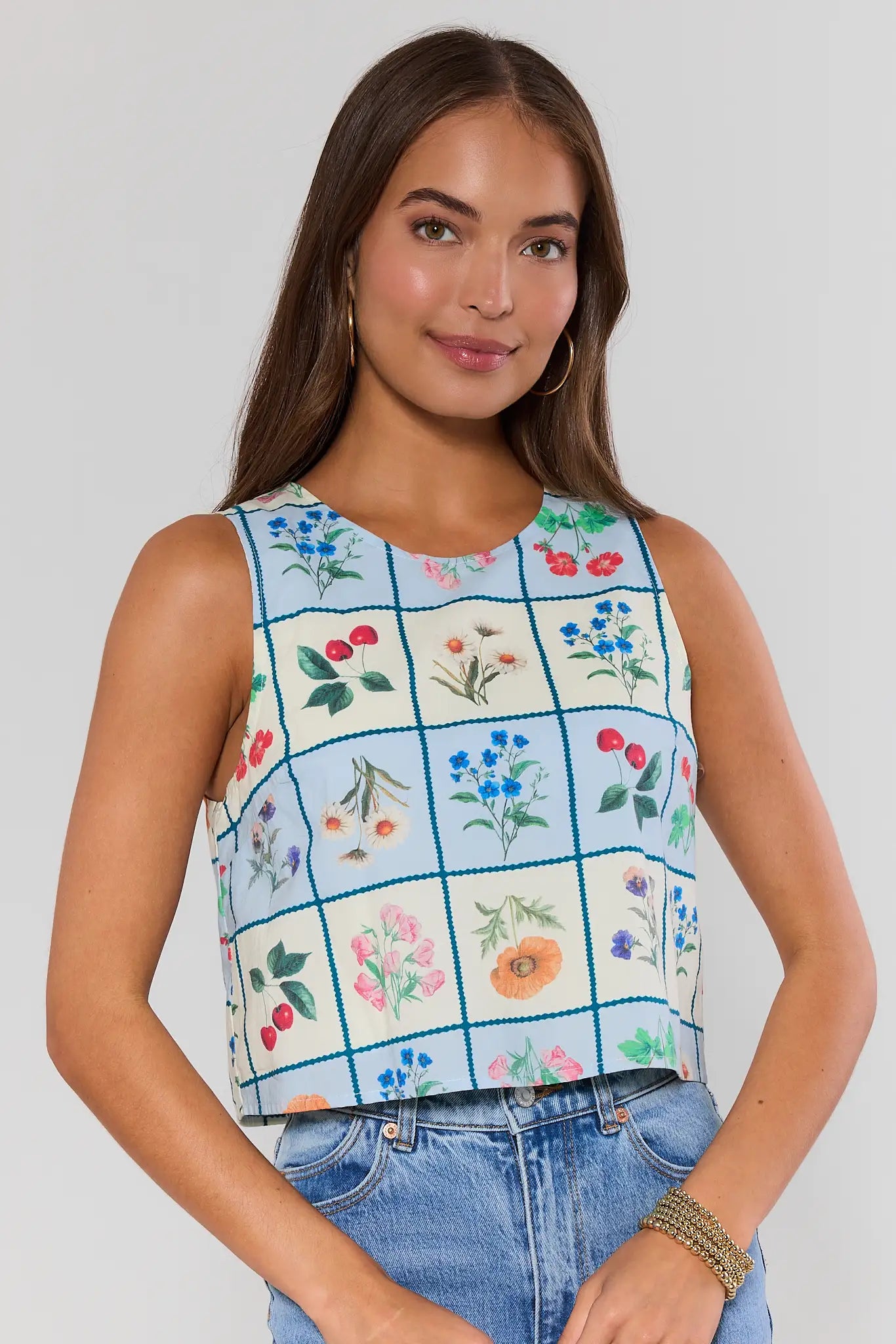 woman wearing blue checkered floral top on white background