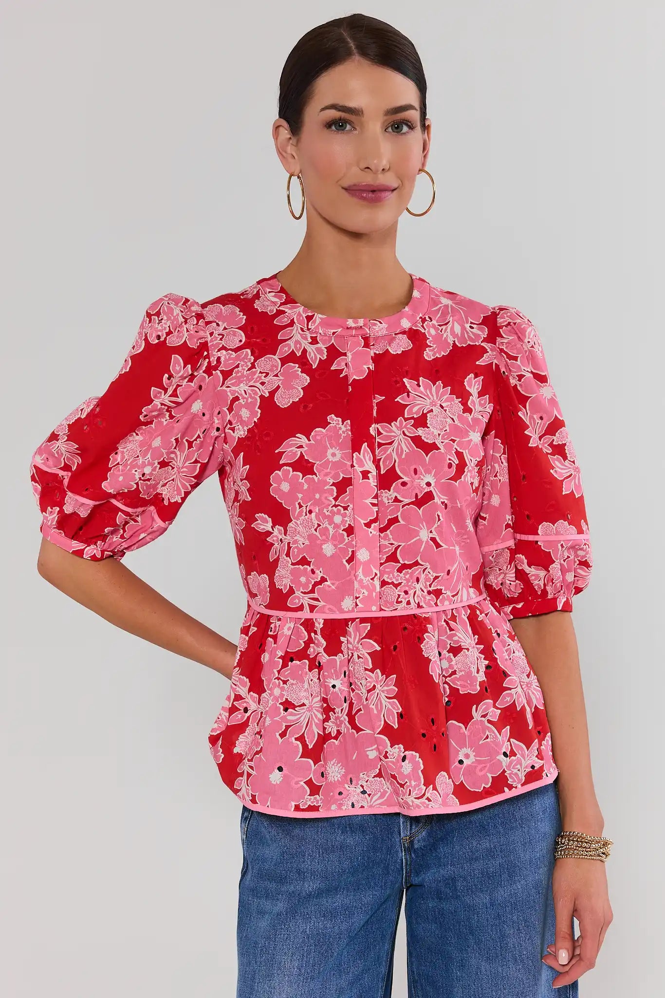 woman wearing red floral eyelet peplum top on white background