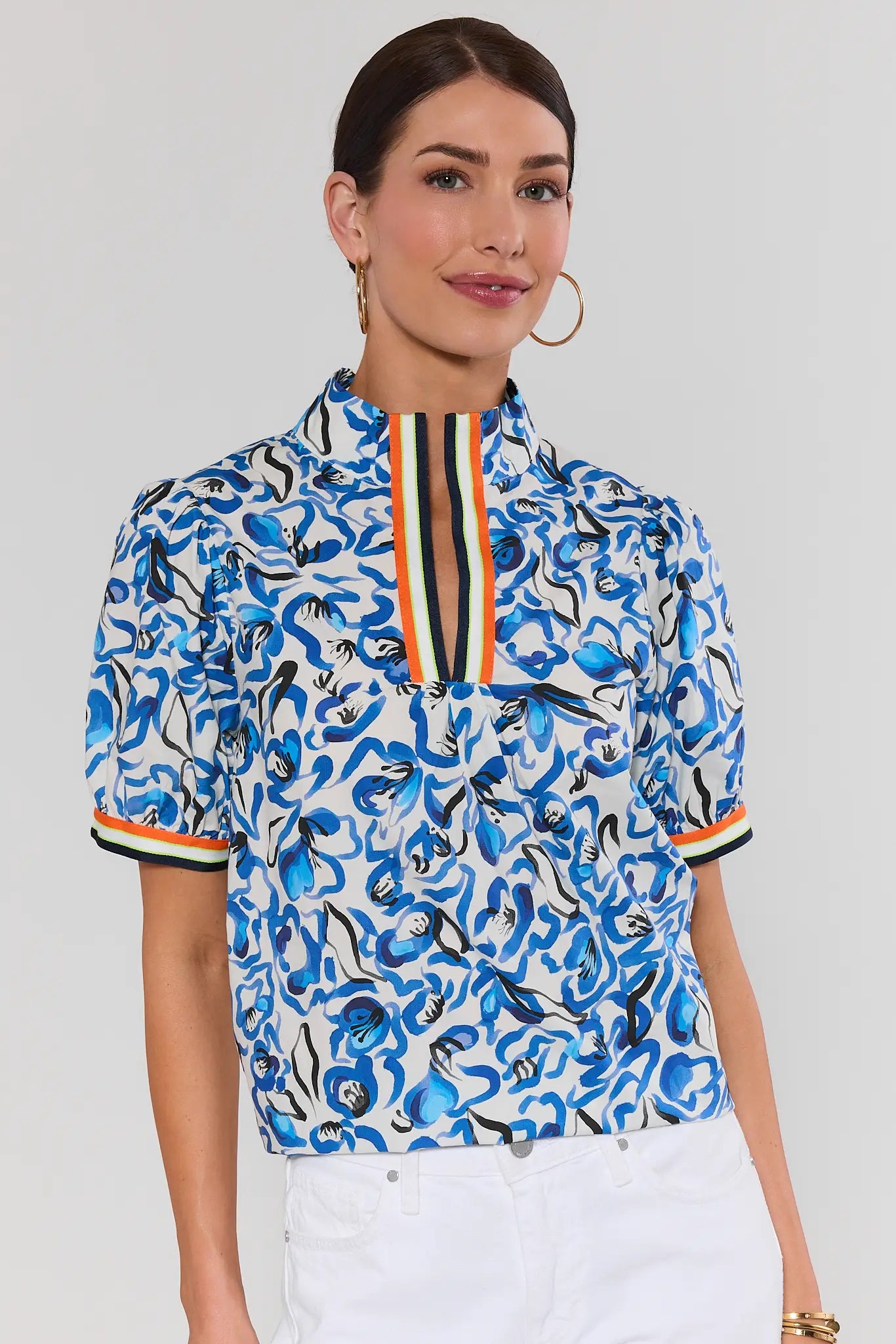 Woman wearing a blue patterned blouse with a white background