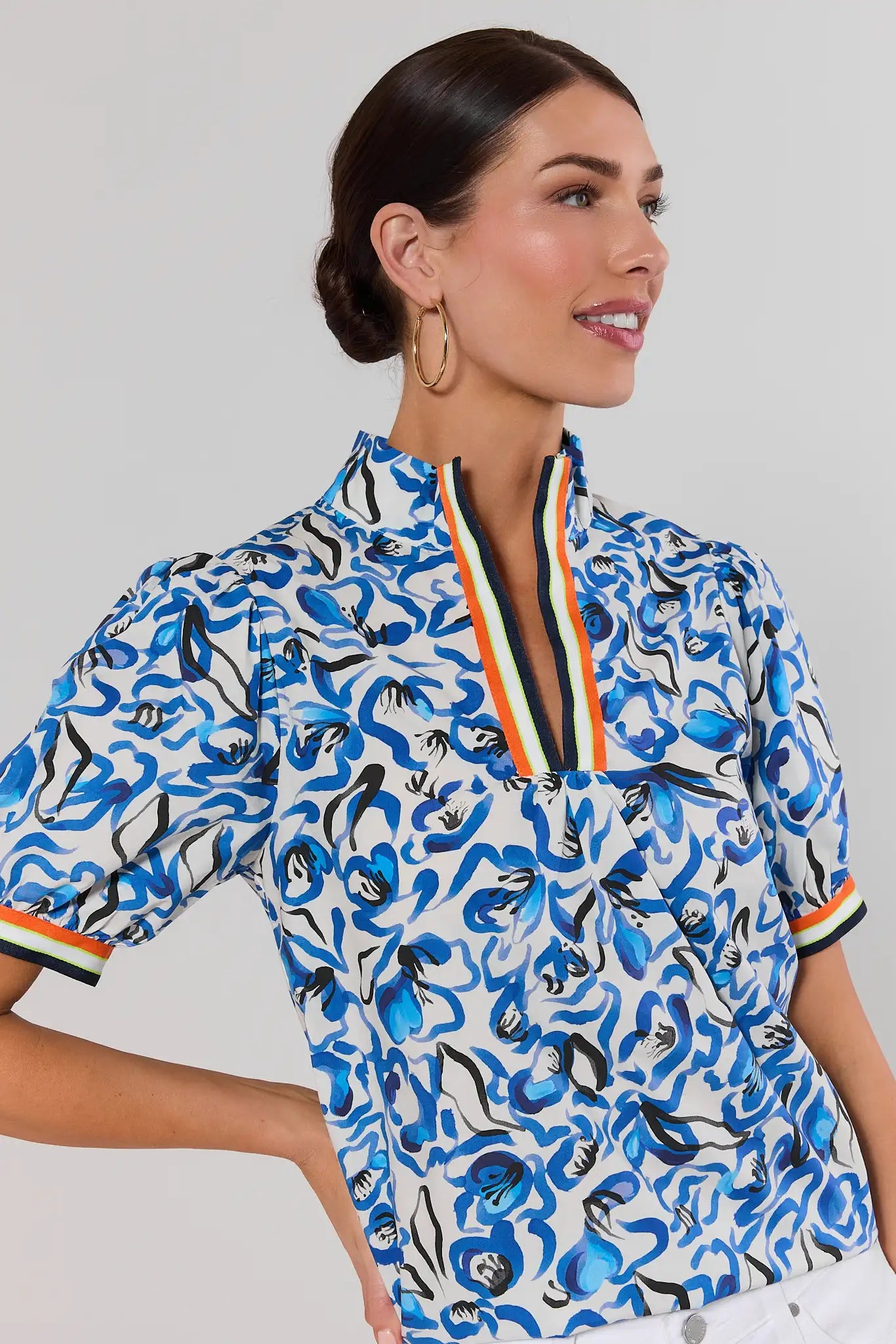 close up Woman wearing a blue patterned blouse with a white background