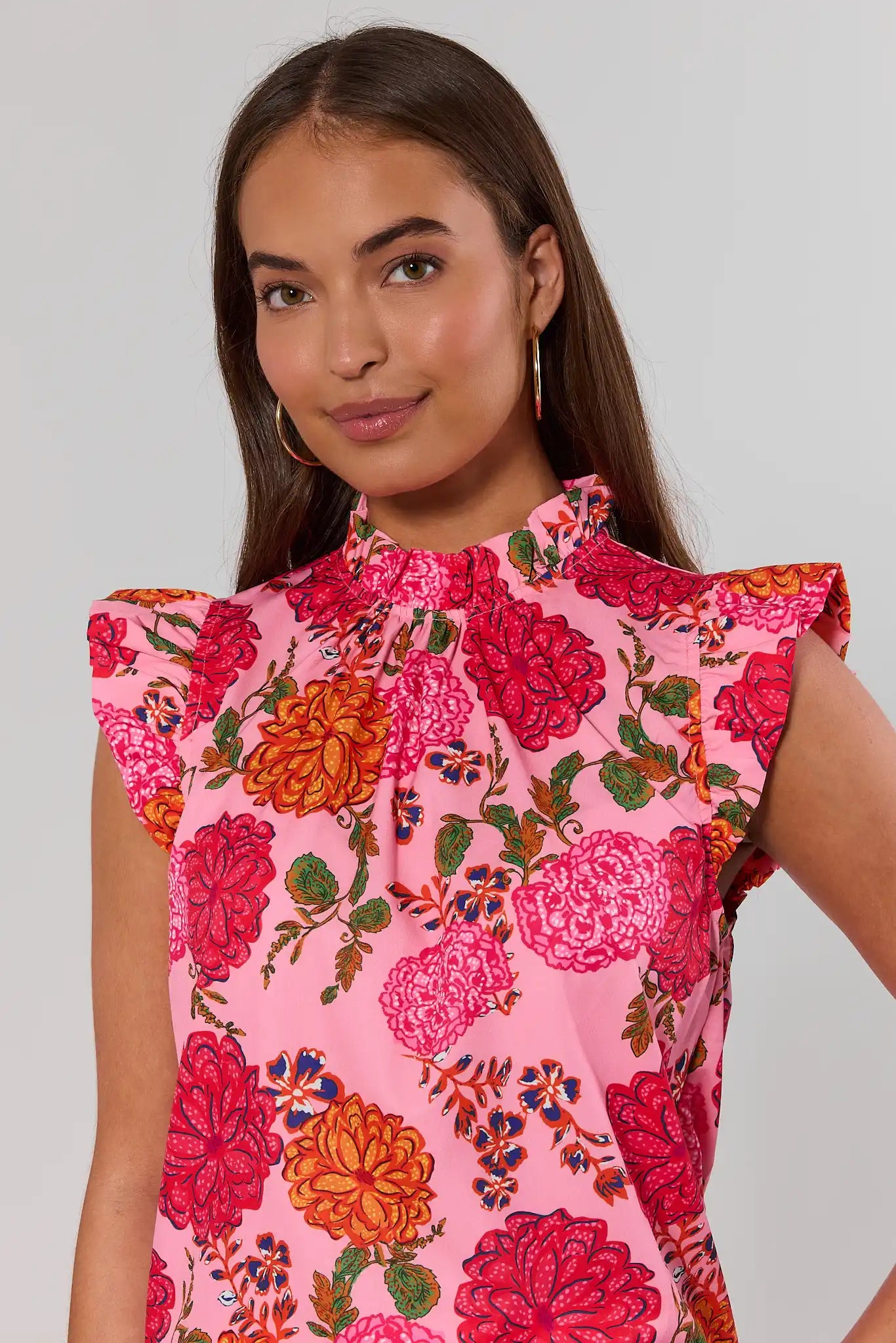 close up Woman wearing a pink floral dress against a plain background