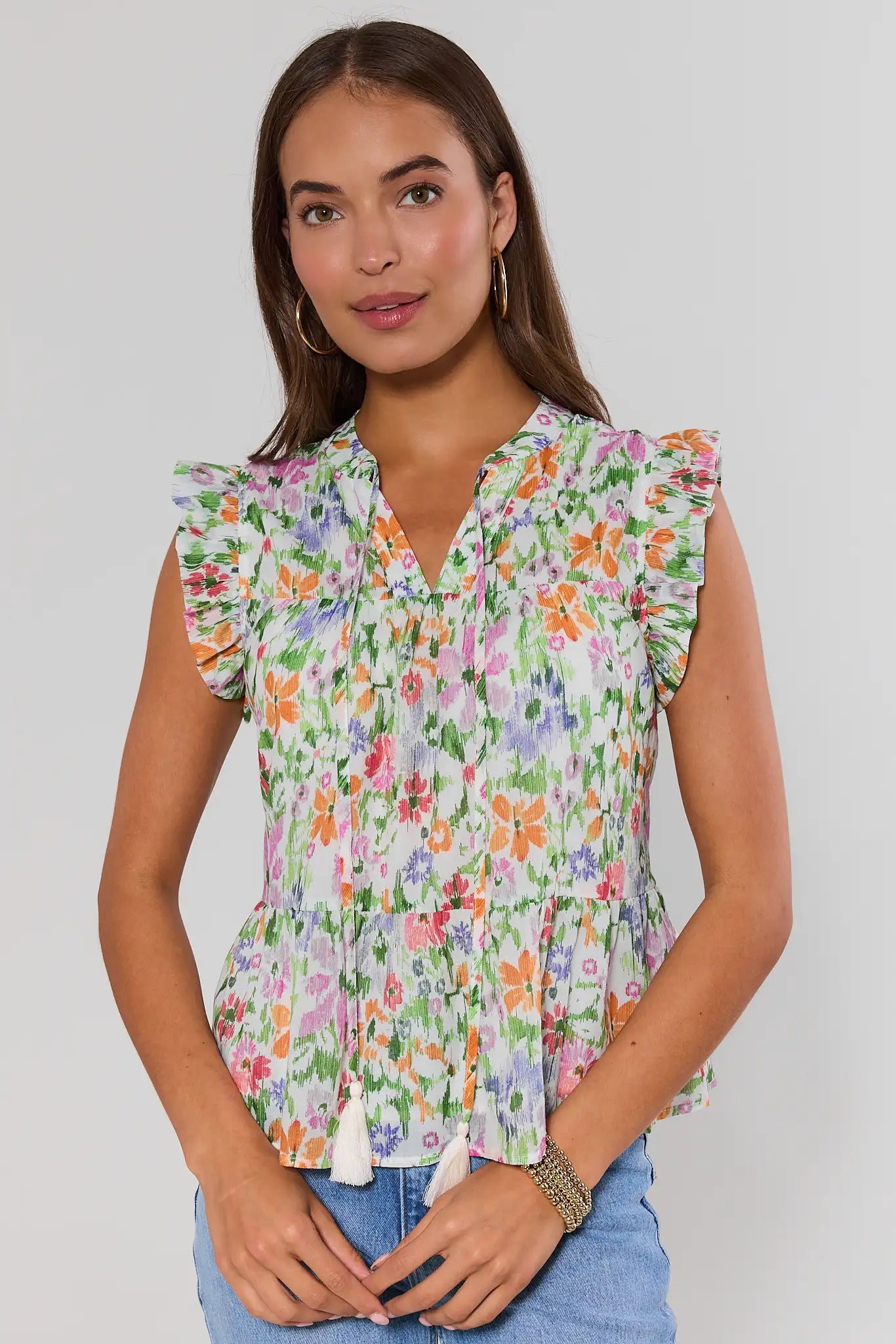 Woman wearing a floral faye blouse with a plain background