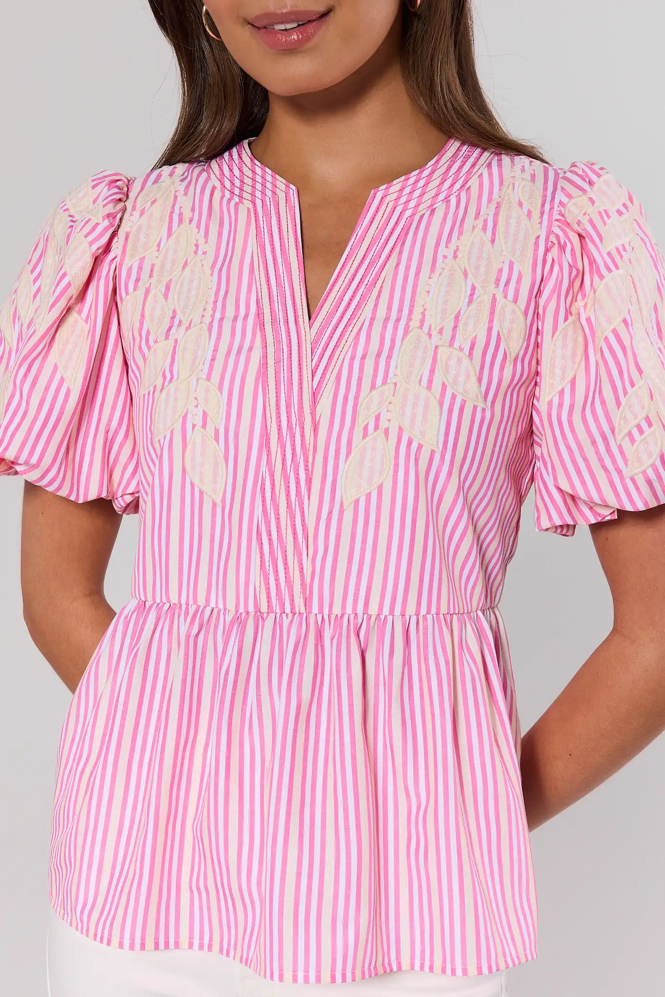 close up Pink and white striped blouse with ruffled sleeves on a plain background