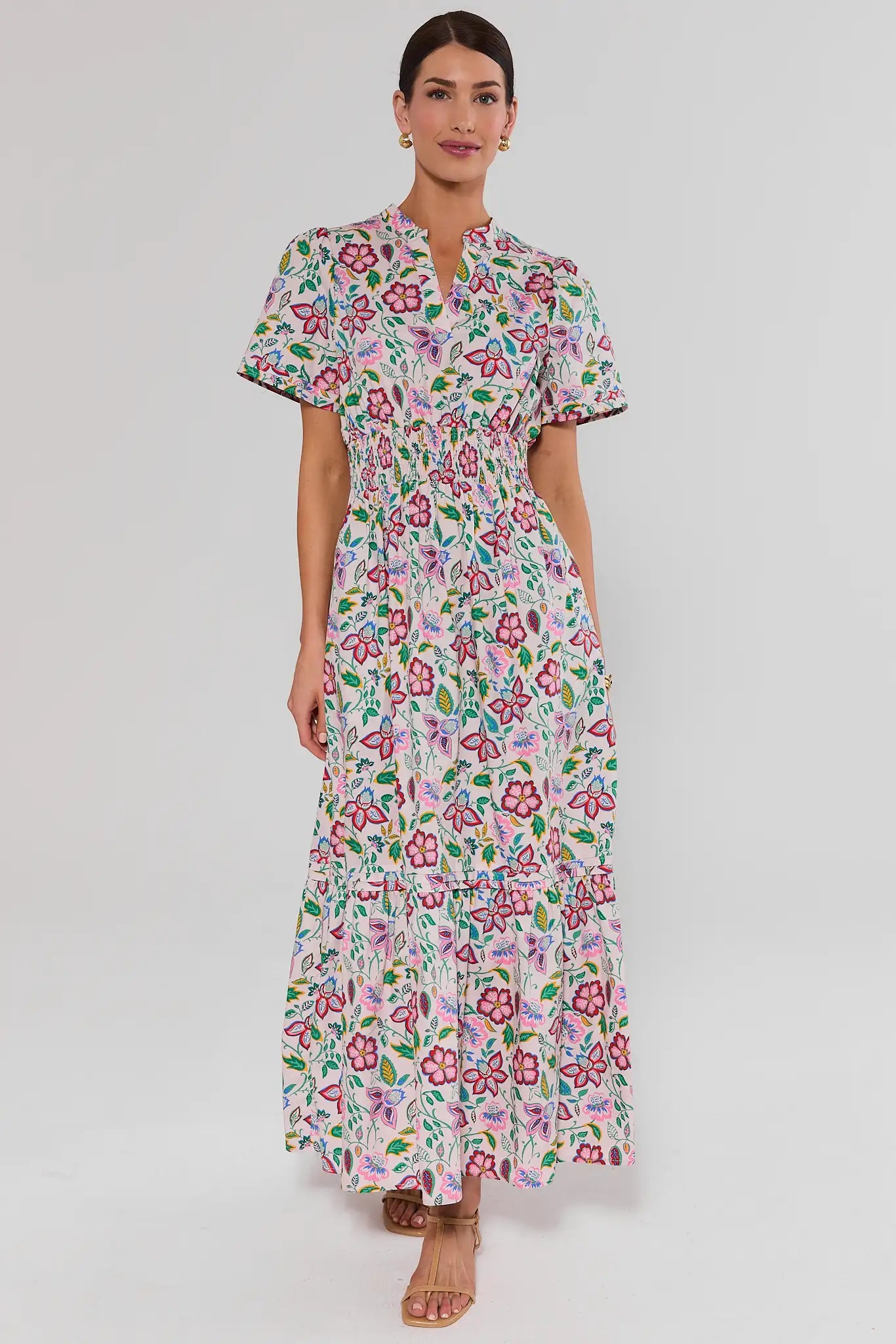 Woman standing wearing a floral dress on a white background