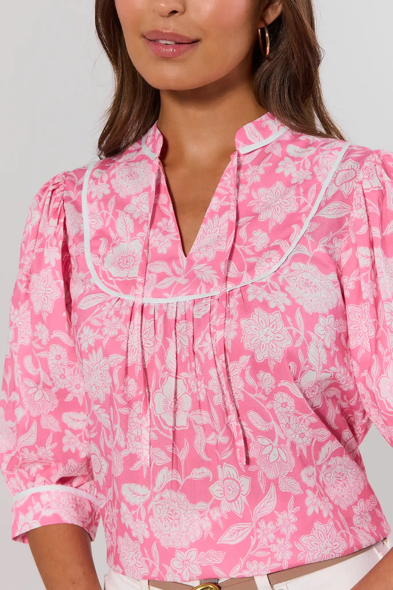 close up Woman wearing a pink floral blouse with a plain background