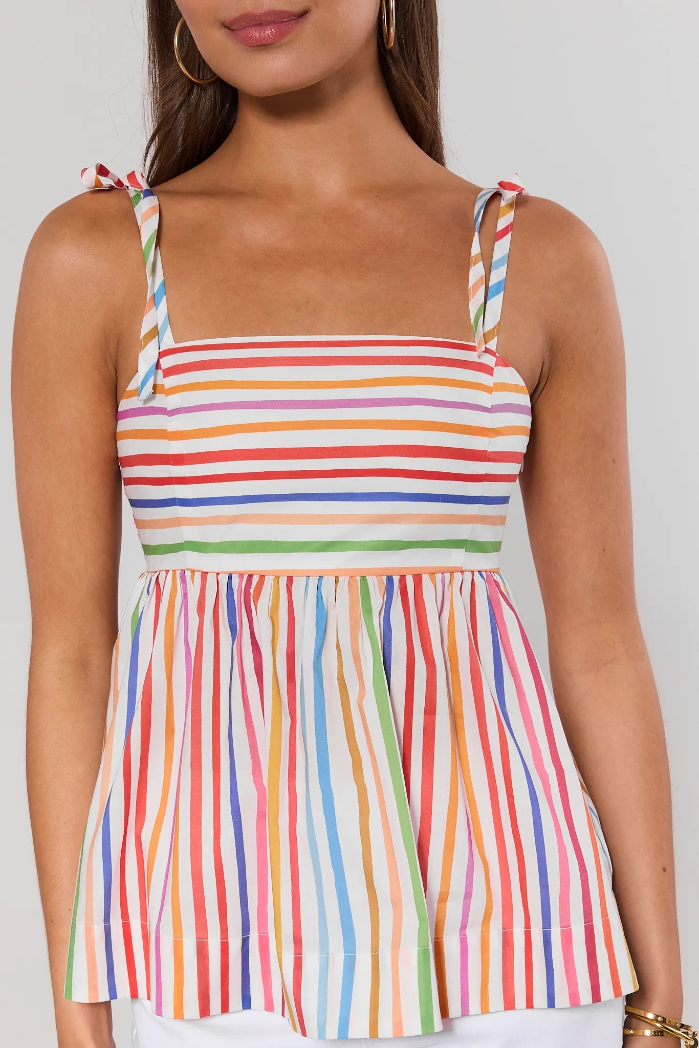 close up Multicolored striped tank top worn by a person on a plain background