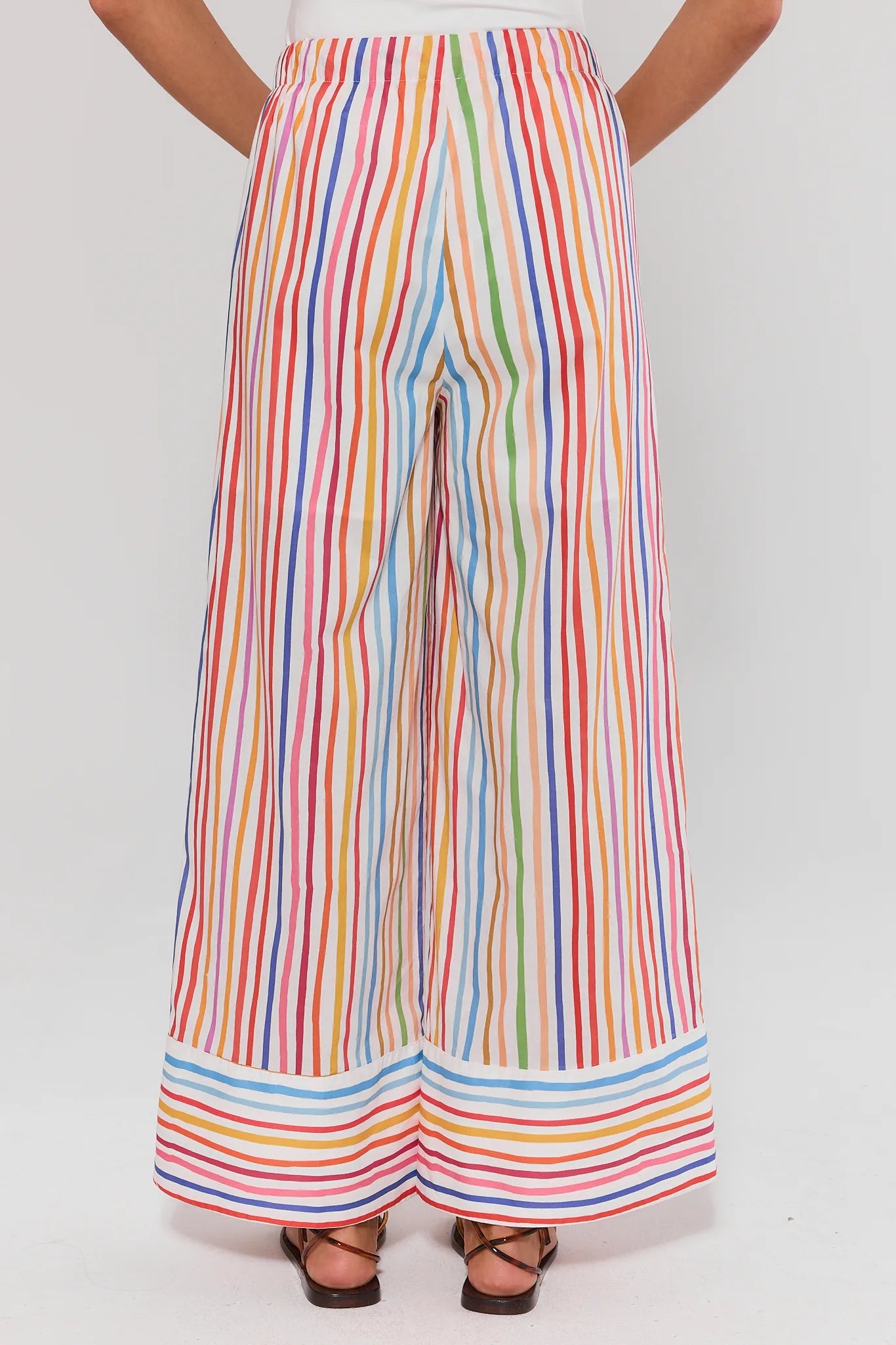 Multicolored striped pants worn by a person on a white background standing