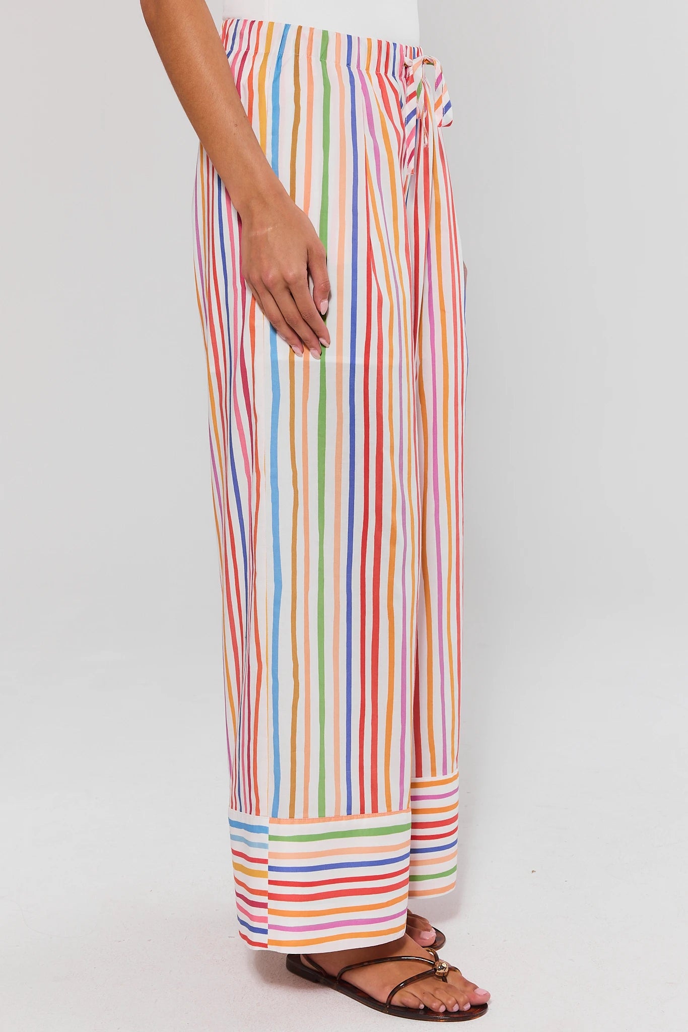 side shot Multicolored striped pants worn by a person on a plain background