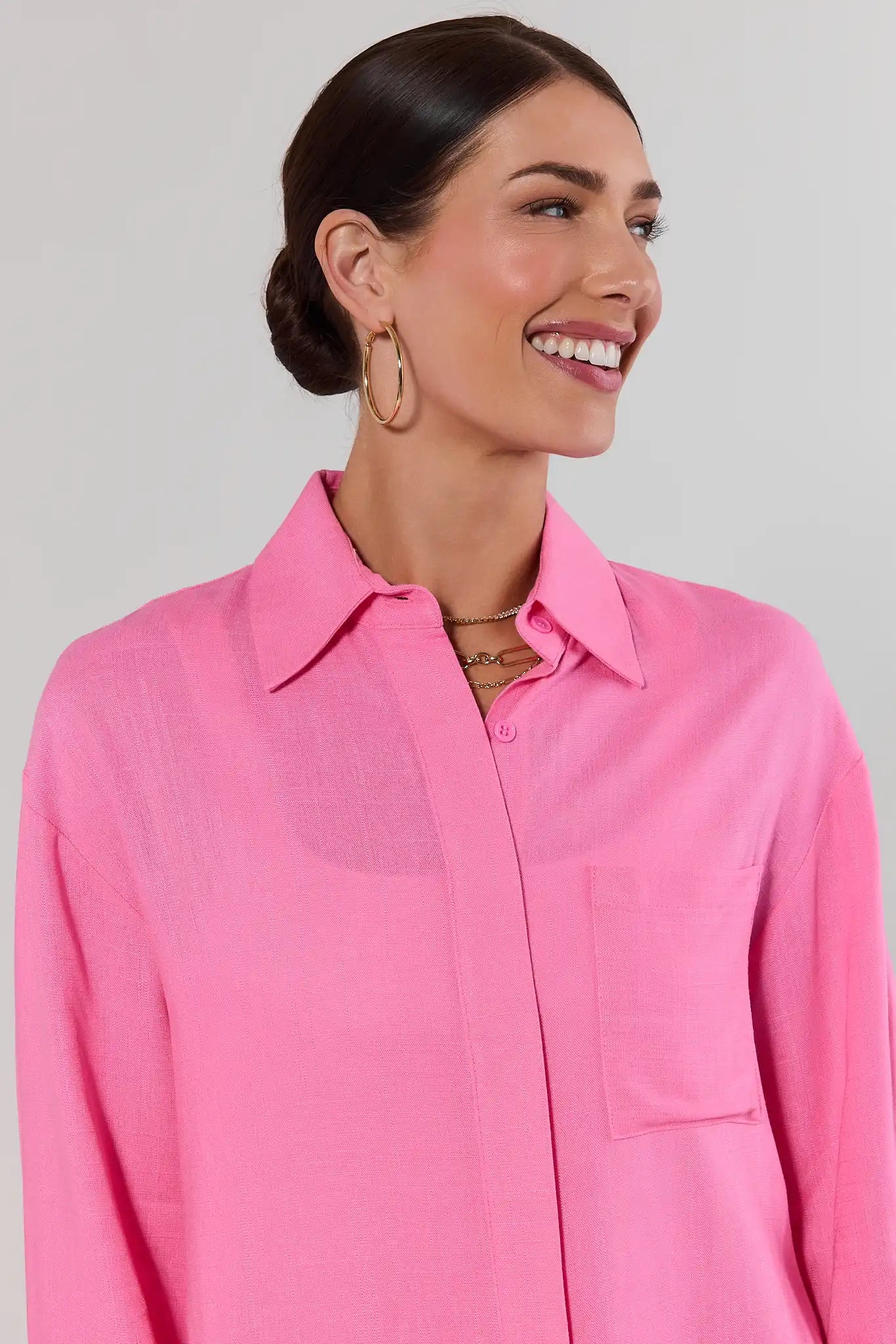 close up Woman wearing a pink shirt against a plain background