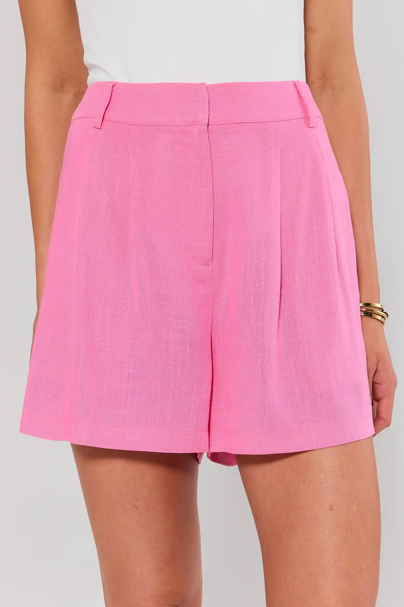 Person wearing bright pink shorts on a plain background