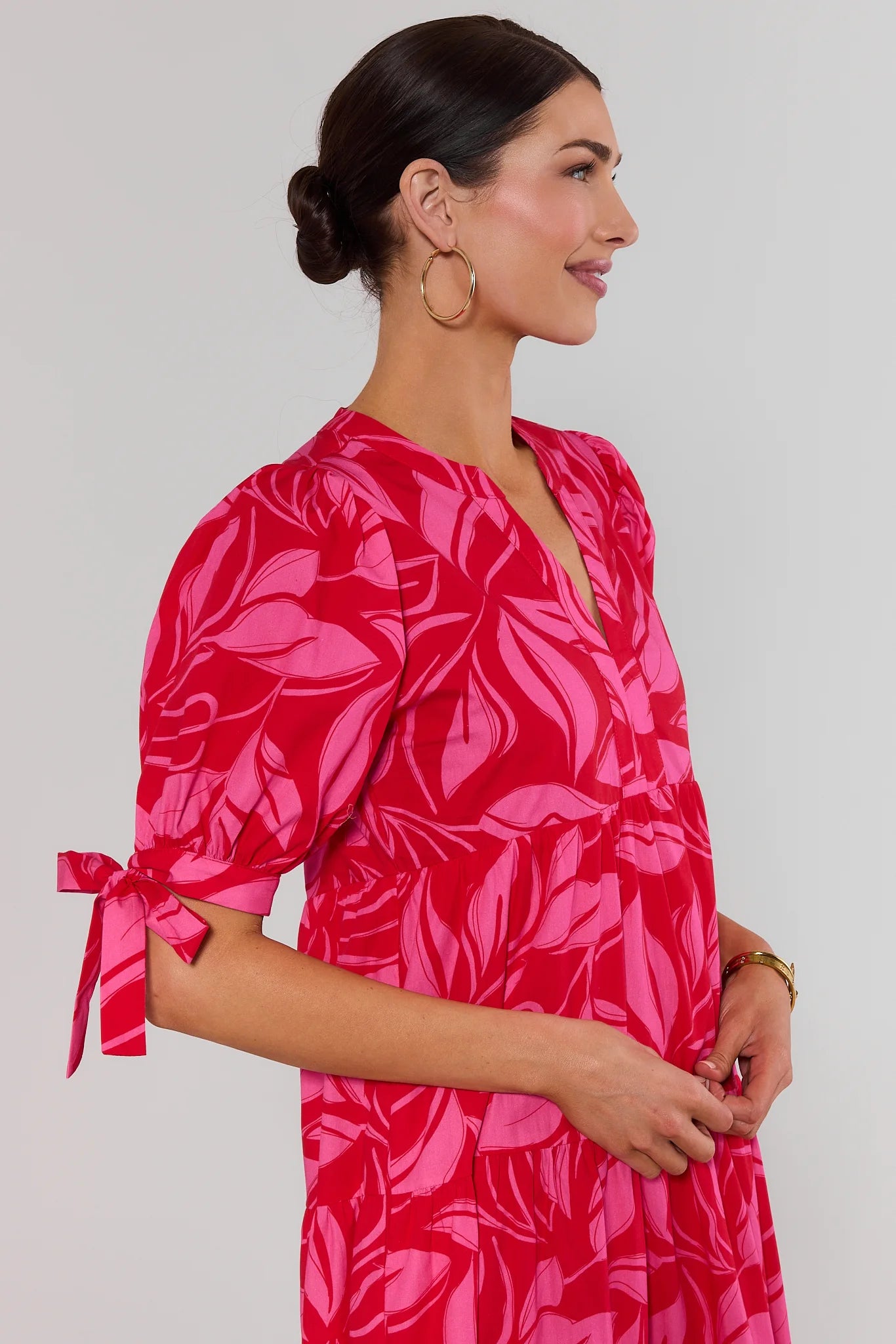 close up Woman wearing a pink floral dress with a plain background
