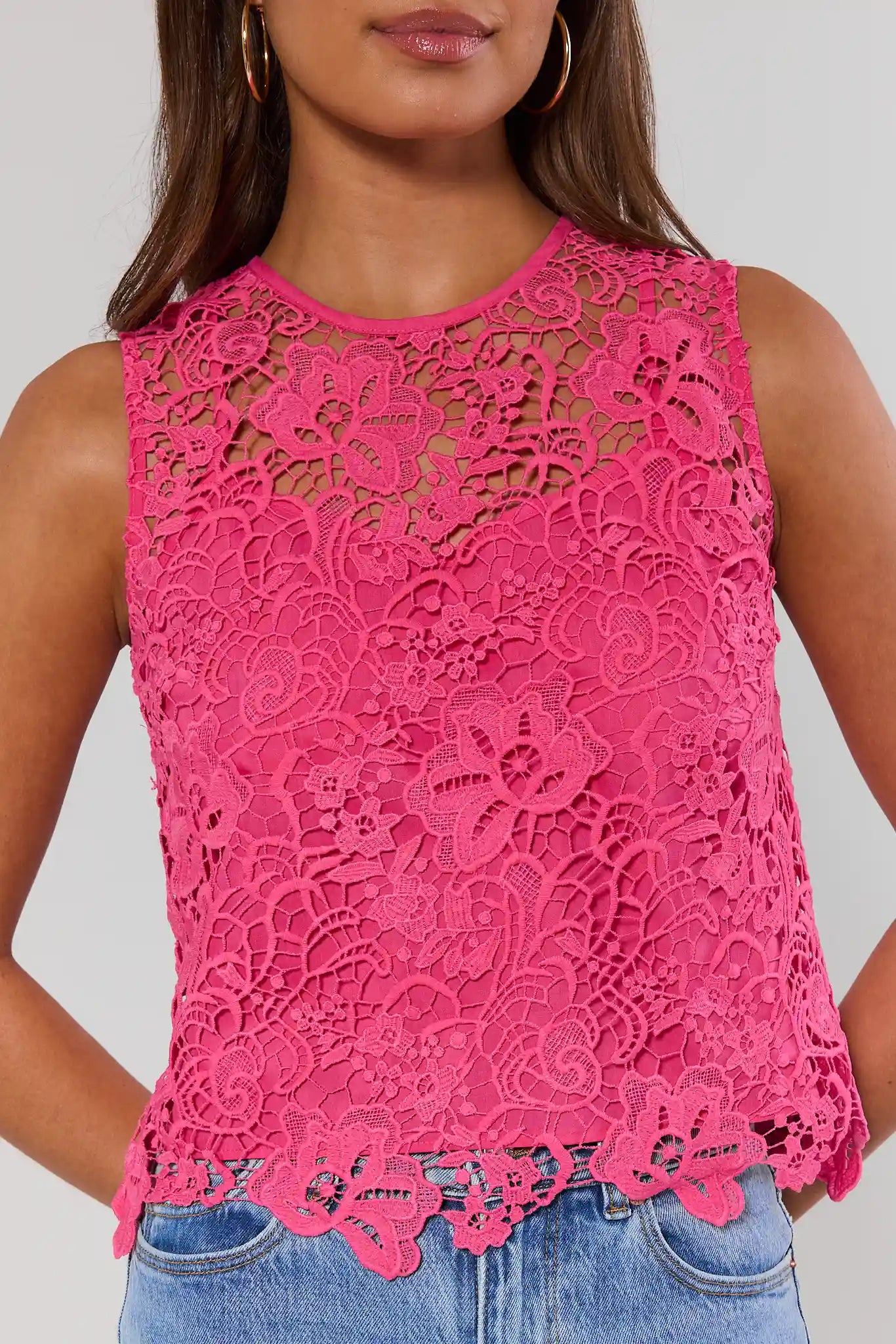 close up Pink lace top worn by a person on a plain background