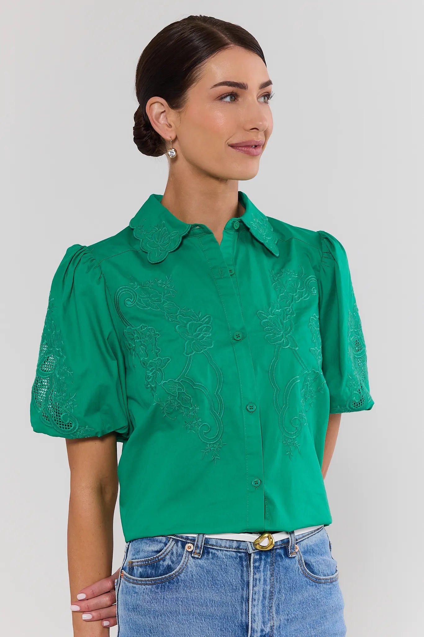 woman wearing green amelia eyelet top on white background