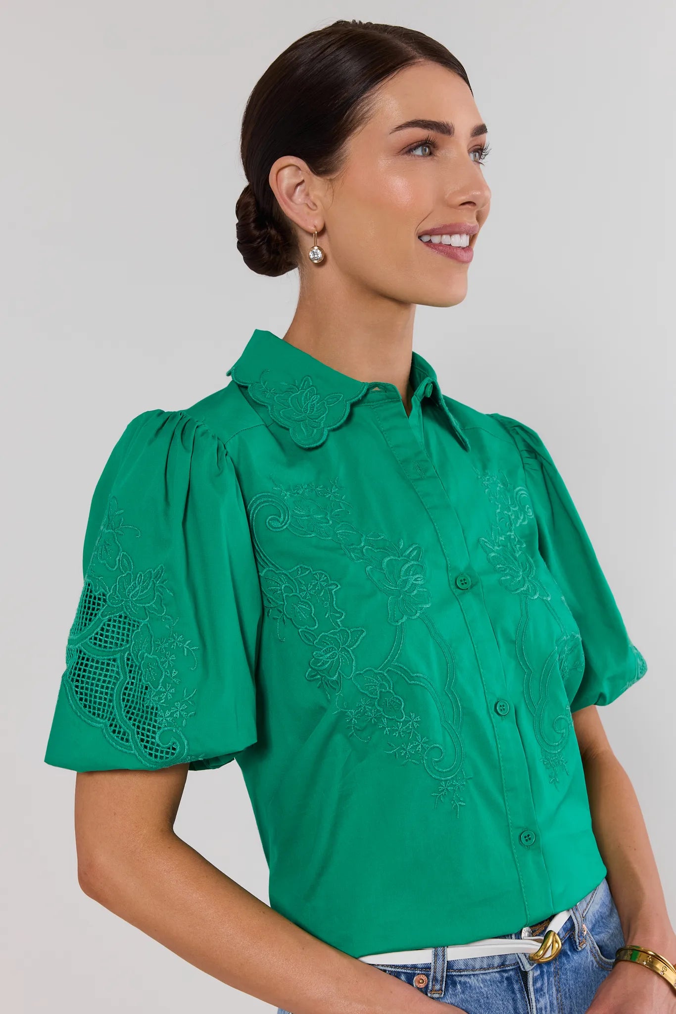 close up woman wearing green amelia eyelet top on white background