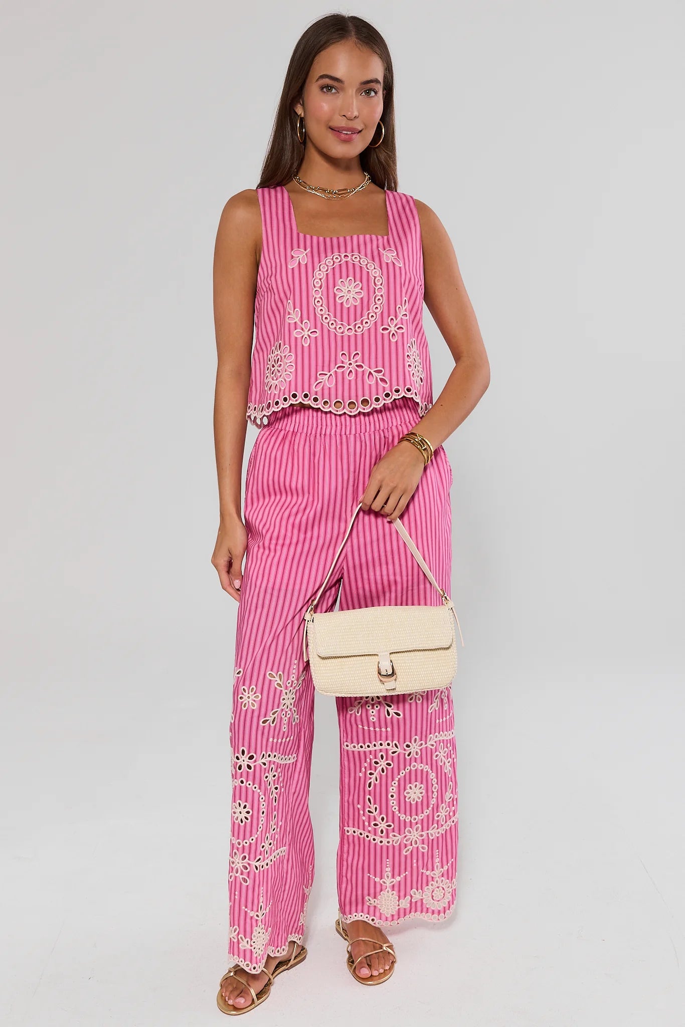 Woman wearing a pink outfit with white patterns on a plain background