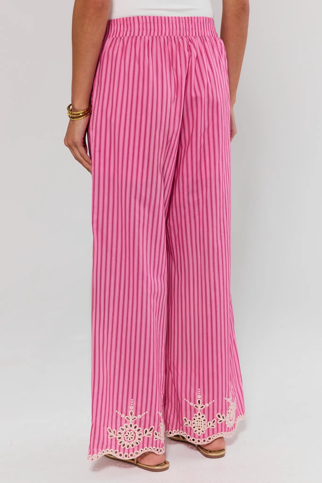 Pink striped pants with lace details on a white background standing
