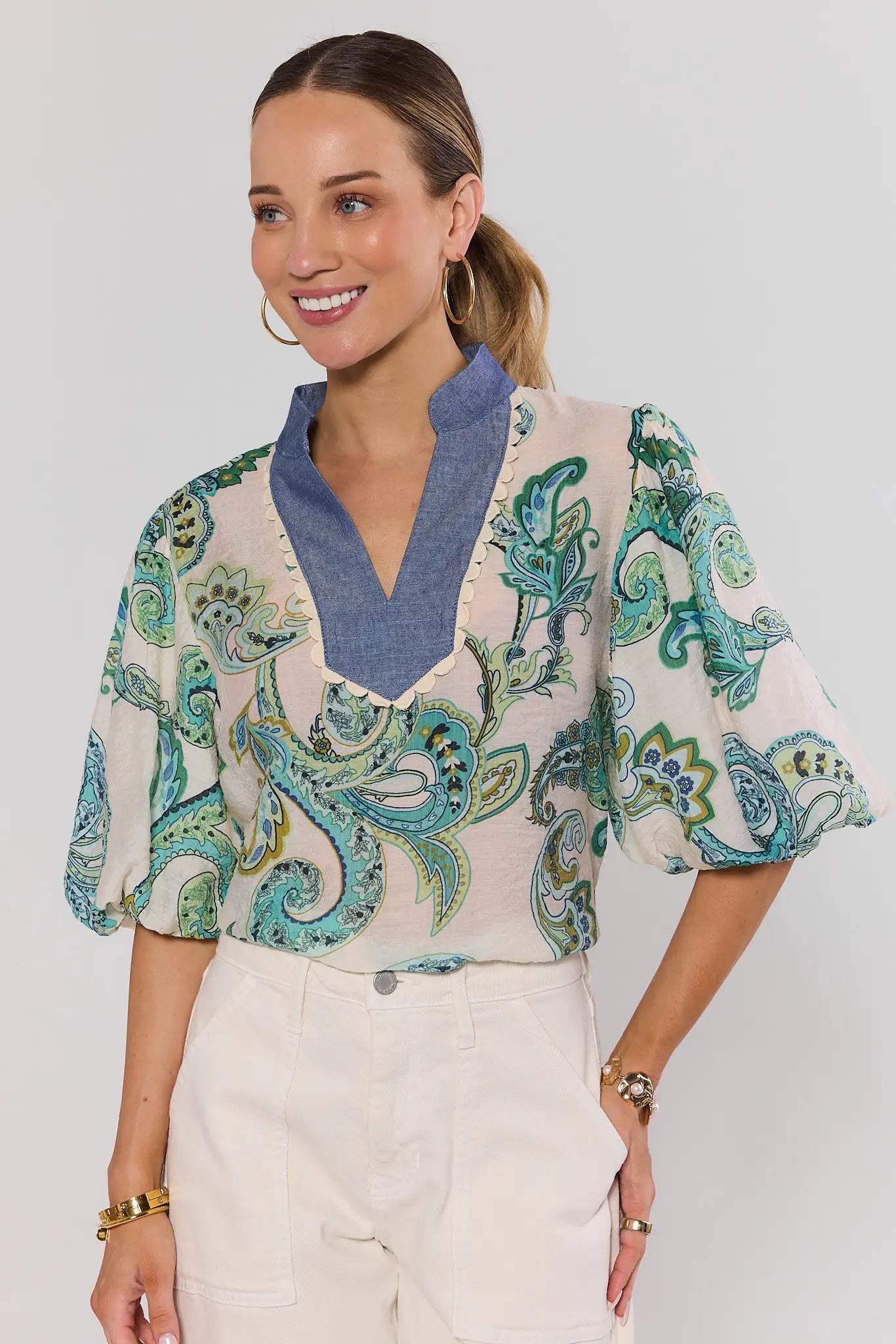 Woman wearing a patterned auriela blouse with a plain background