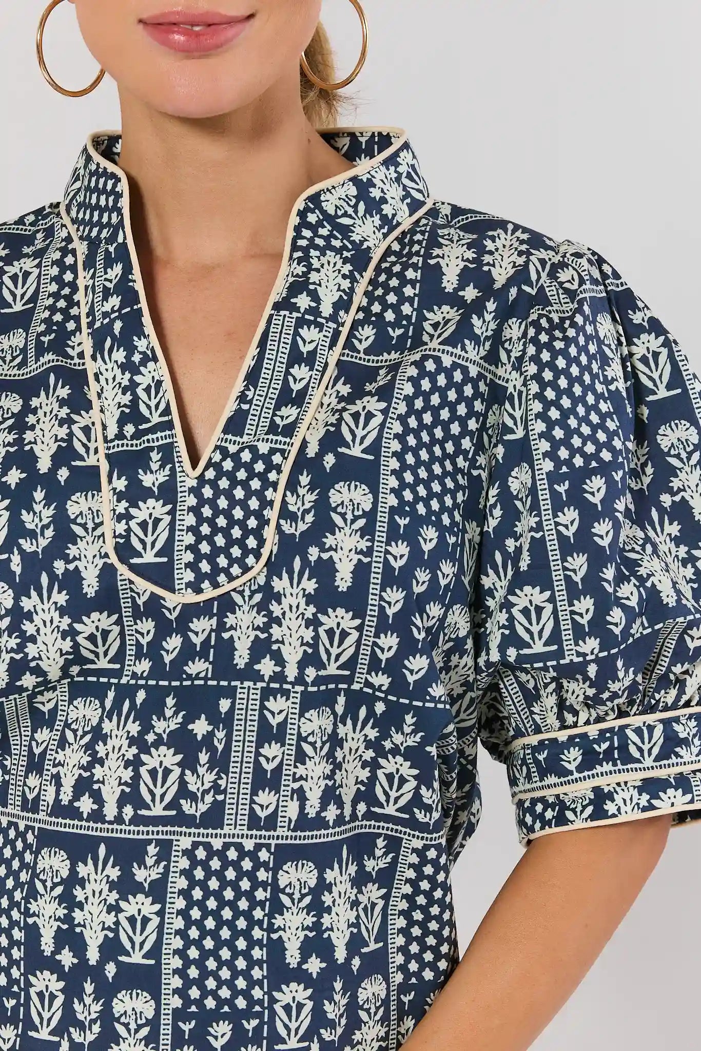 close up Navy blue and white patterned dress with a close-up of the neckline on a plain background