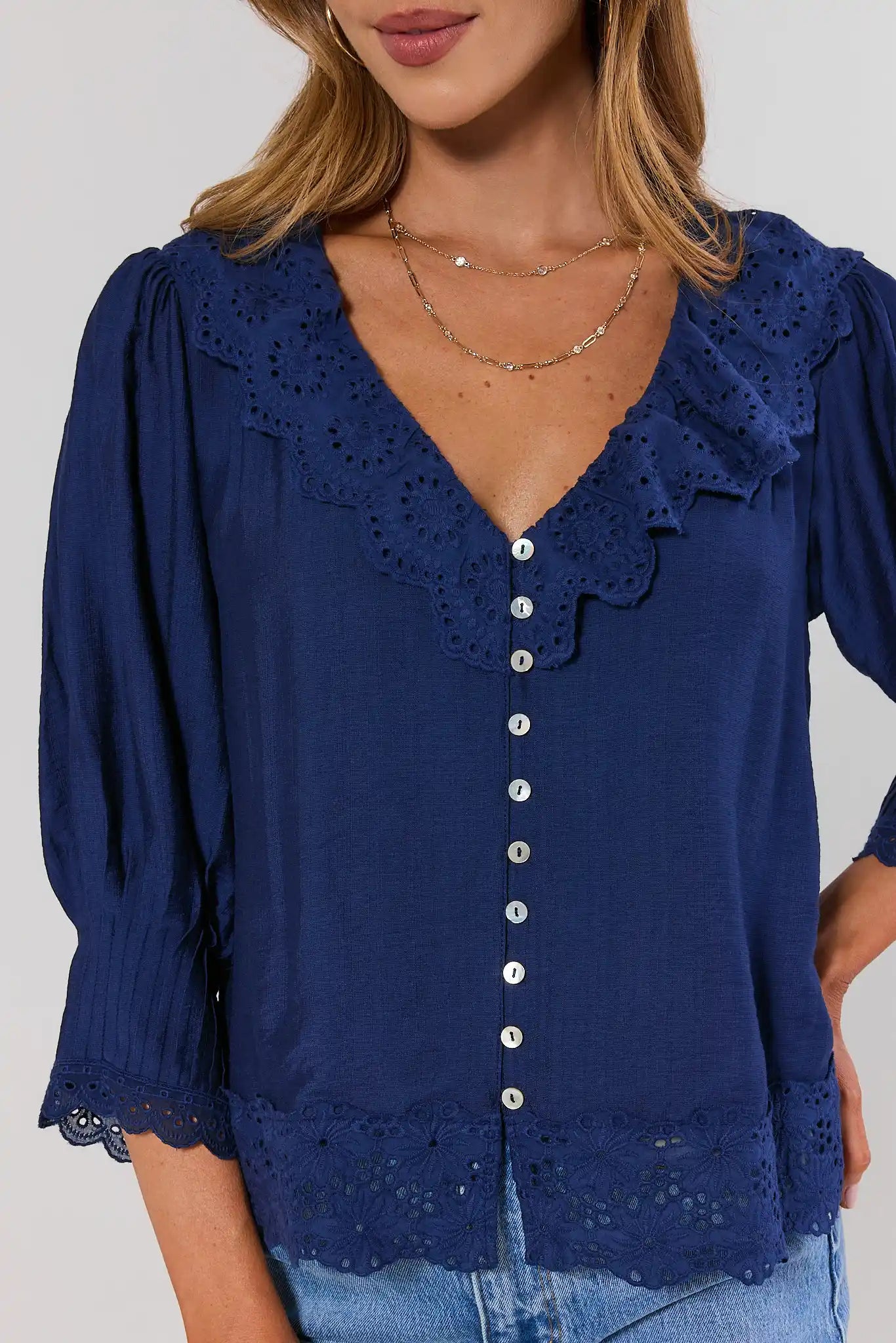 close up Navy blue blouse with lace details on a plain background