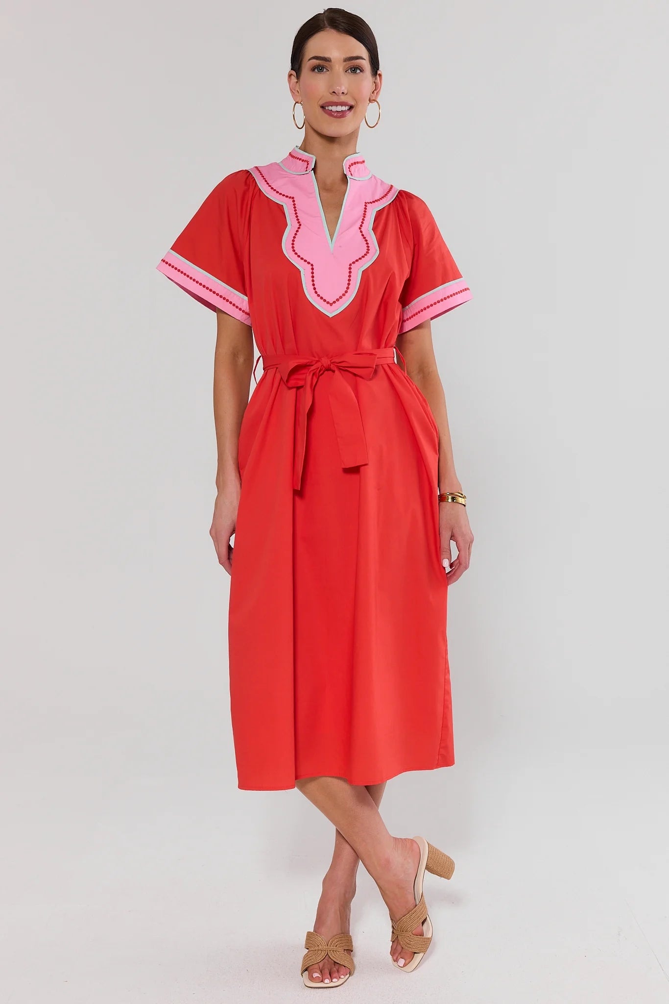 Woman wearing a red dress with pink accents and blue on a white background