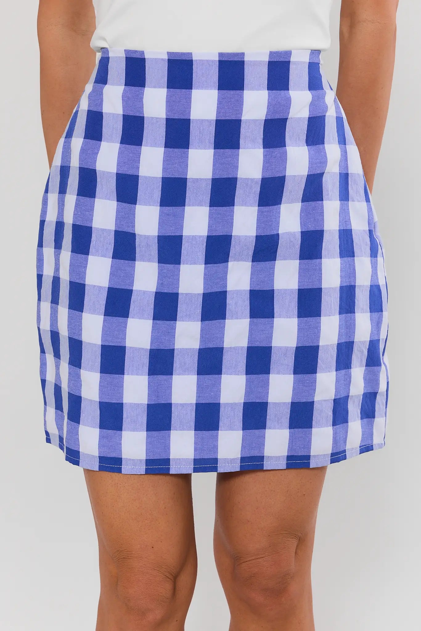 Blue and white checkered skirt worn by a person on a plain background