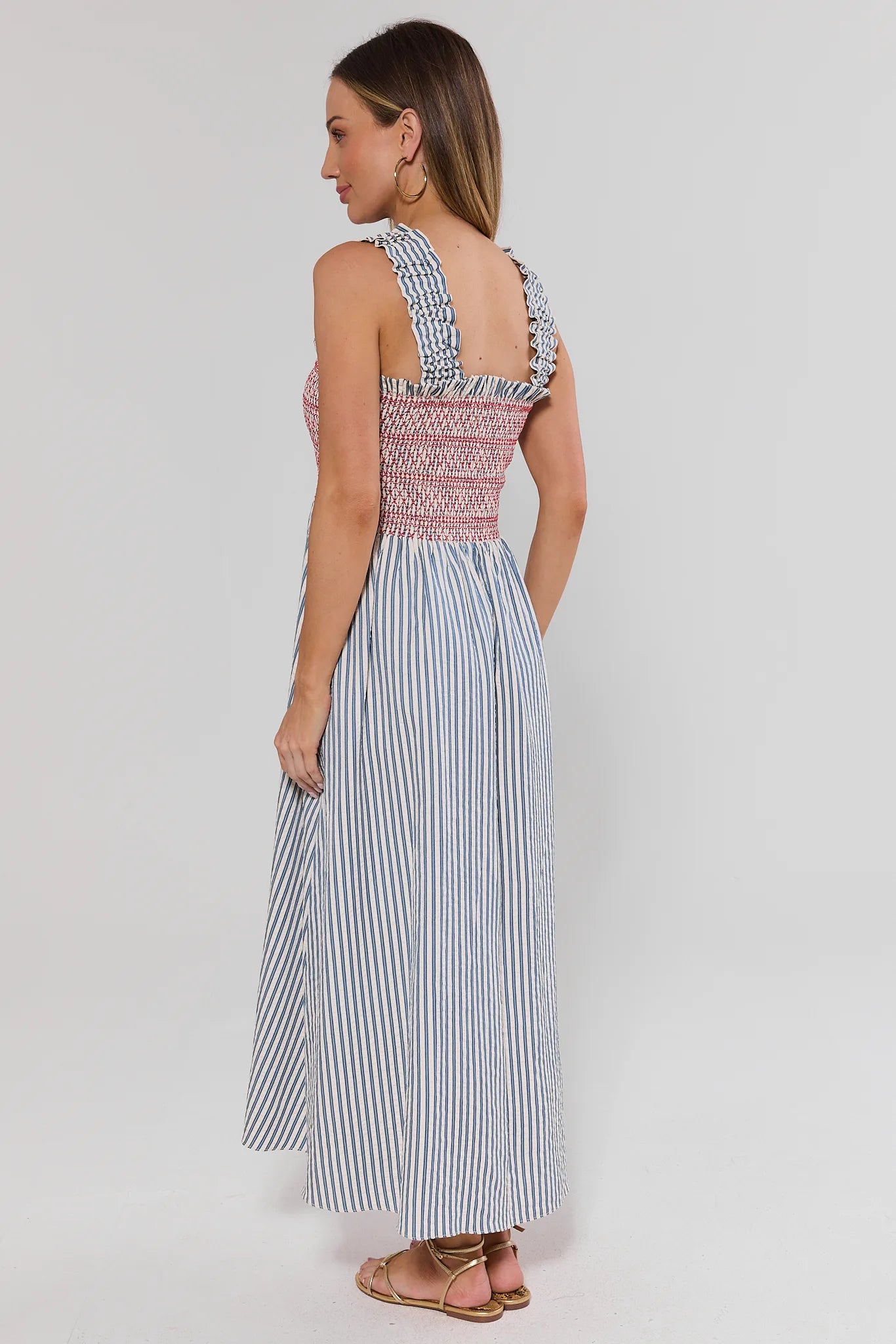 Woman wearing a striped dress with a white background standing