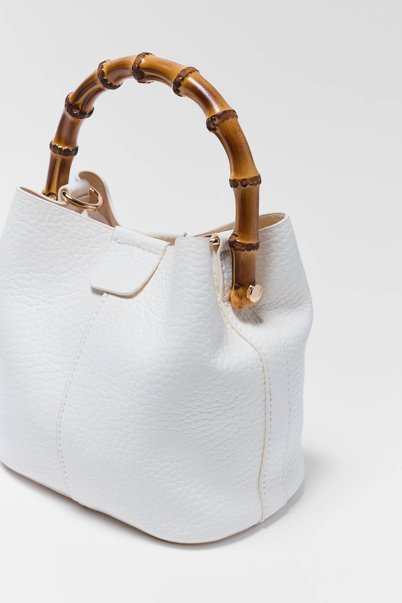 White handbag with bamboo handle on a white background close up