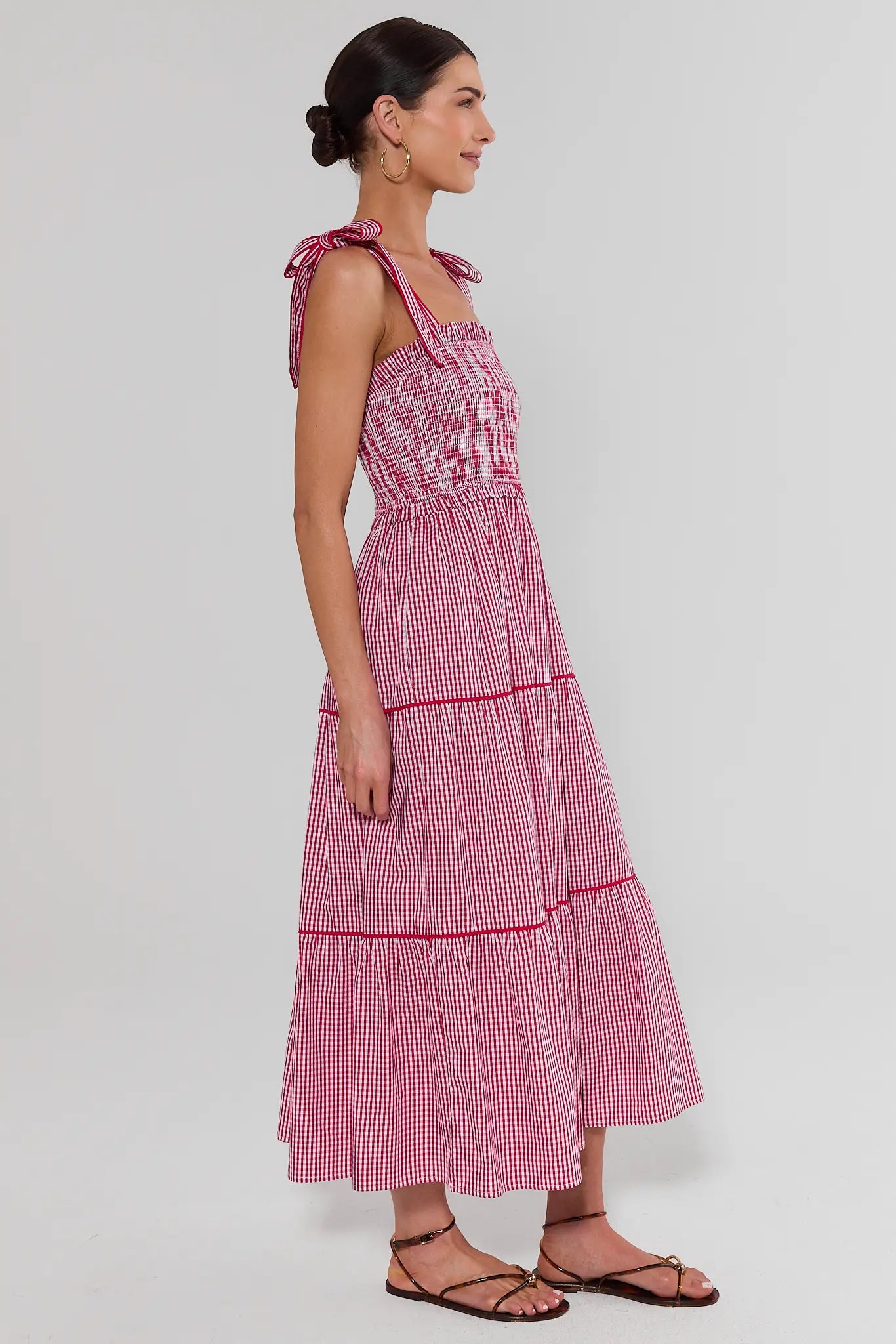 Woman wearing a red and white checkered dress on a white background side