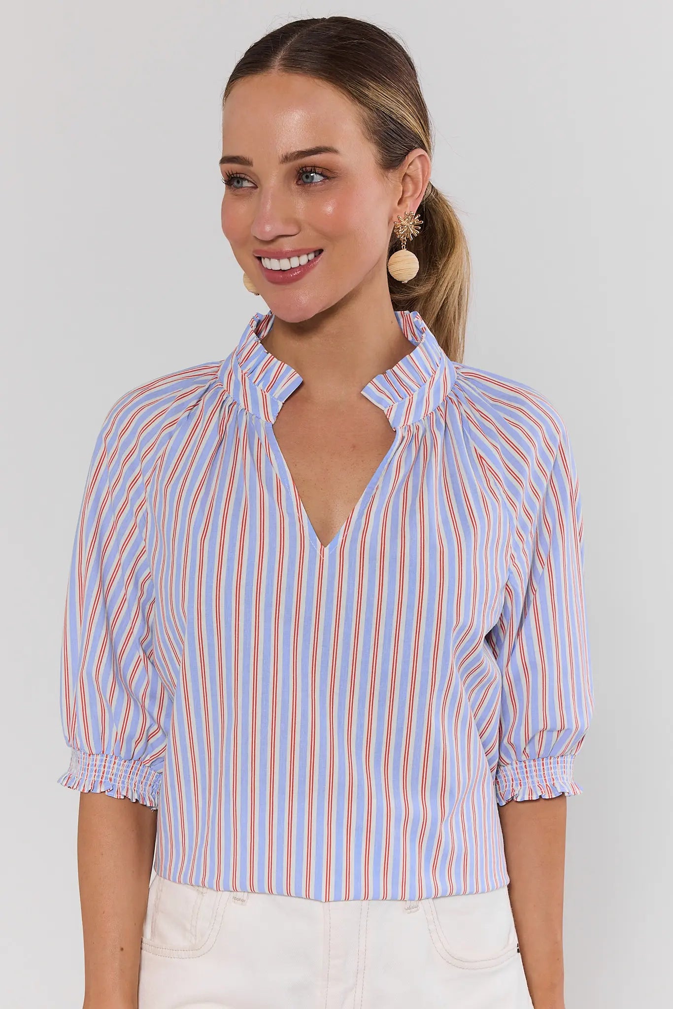 Woman wearing a striped shirt with a plain background