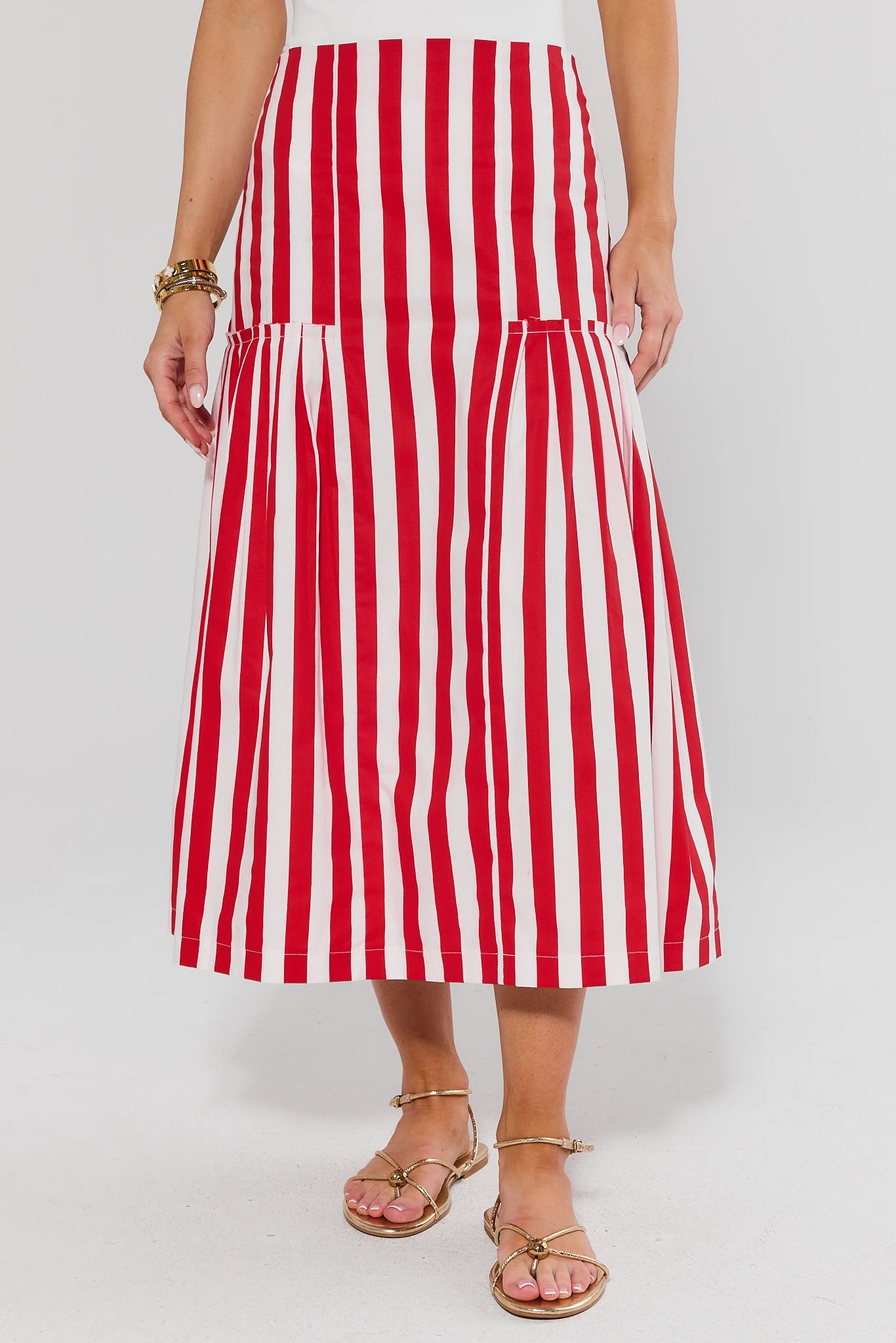 Red and white striped skirt worn by a person on a plain background