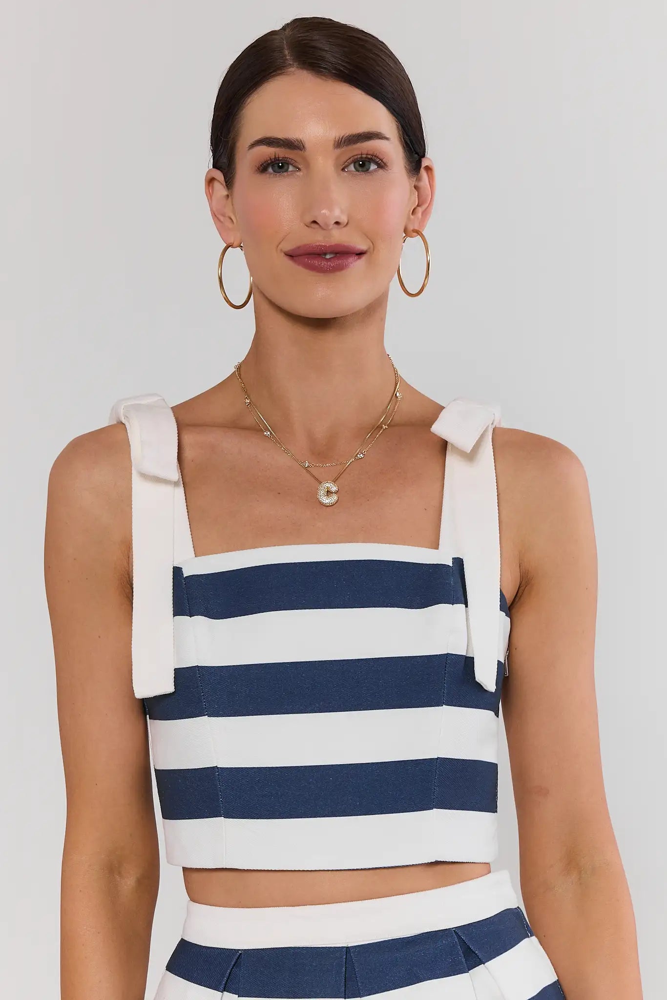 Woman wearing a blue and white striped top with a plain background