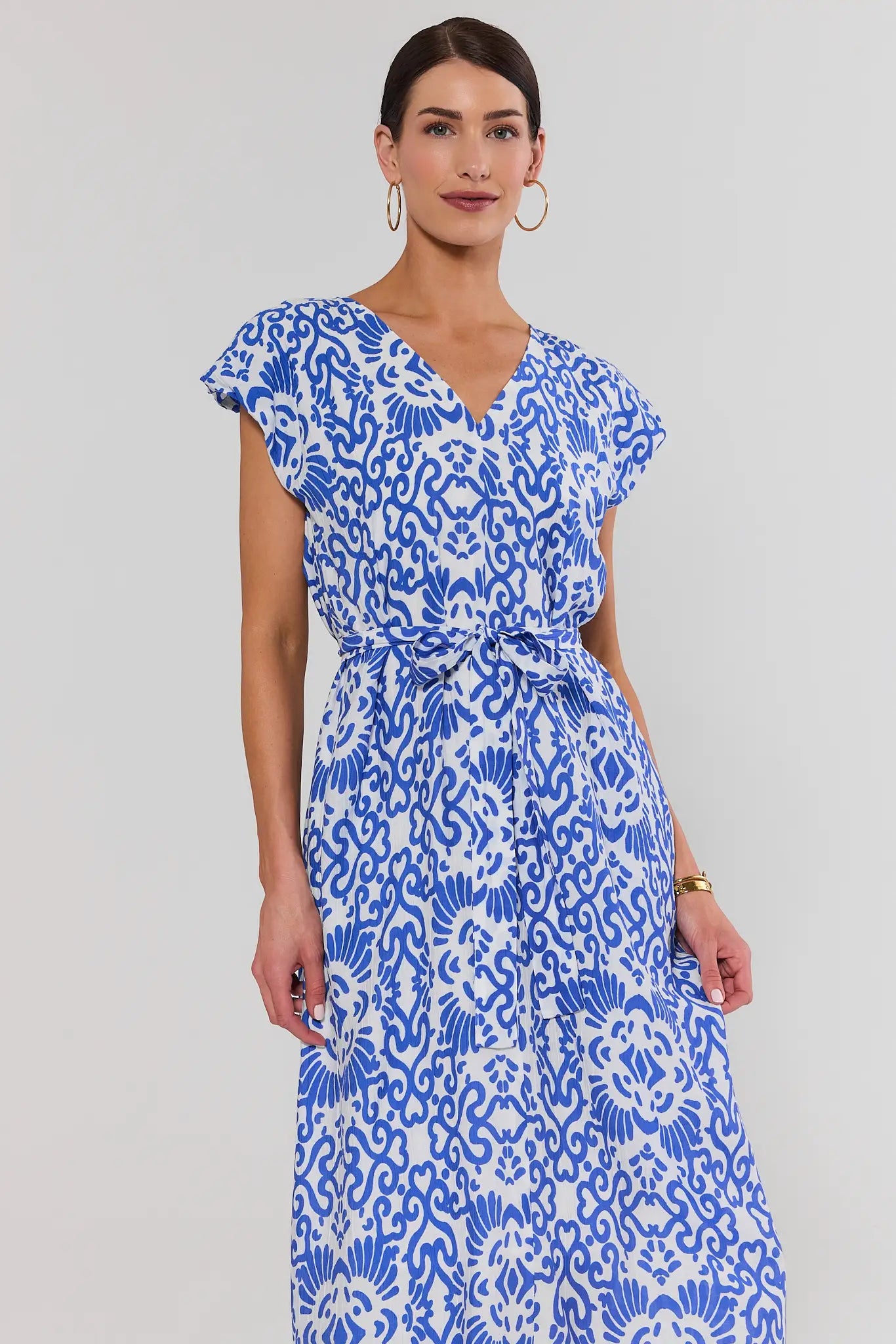 Woman wearing a blue and white patterned dress on a gray background