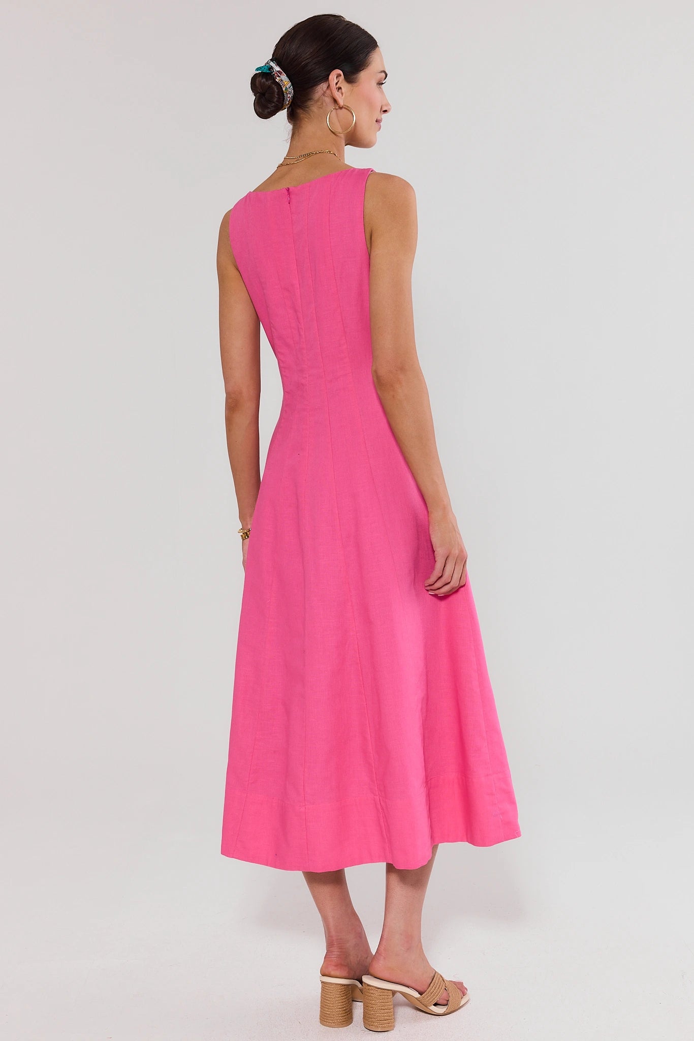 Woman wearing a pink dress on a white background standing