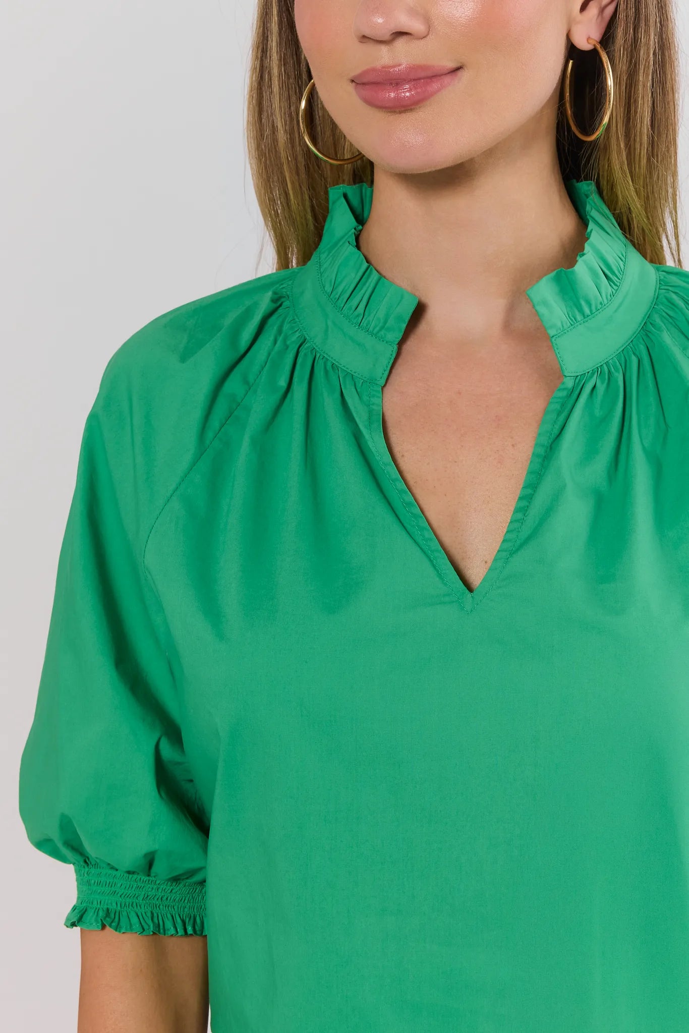 close up Green blouse with puff sleeves worn by a model on a plain background