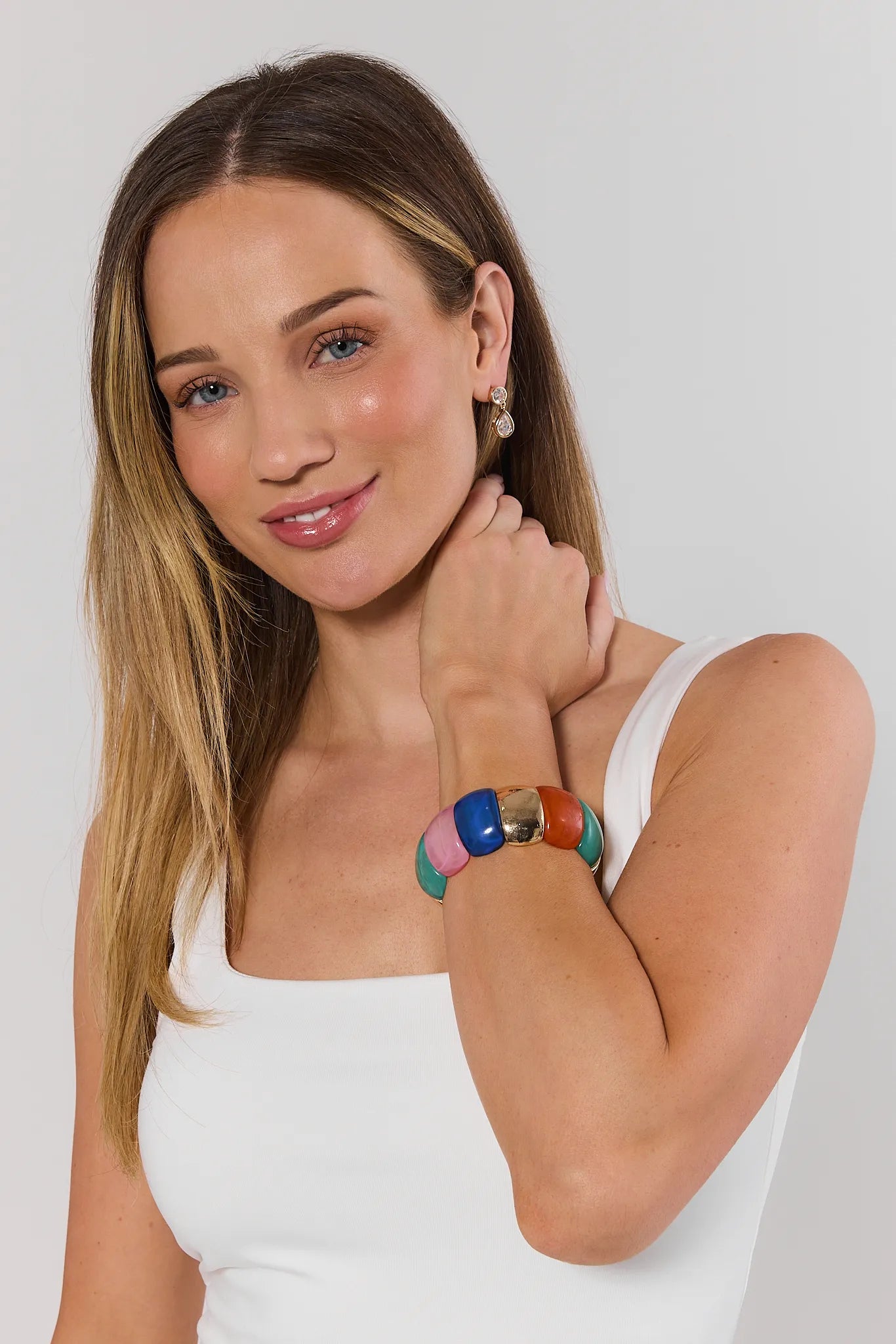 Woman wearing a colorful bracelet on a plain background