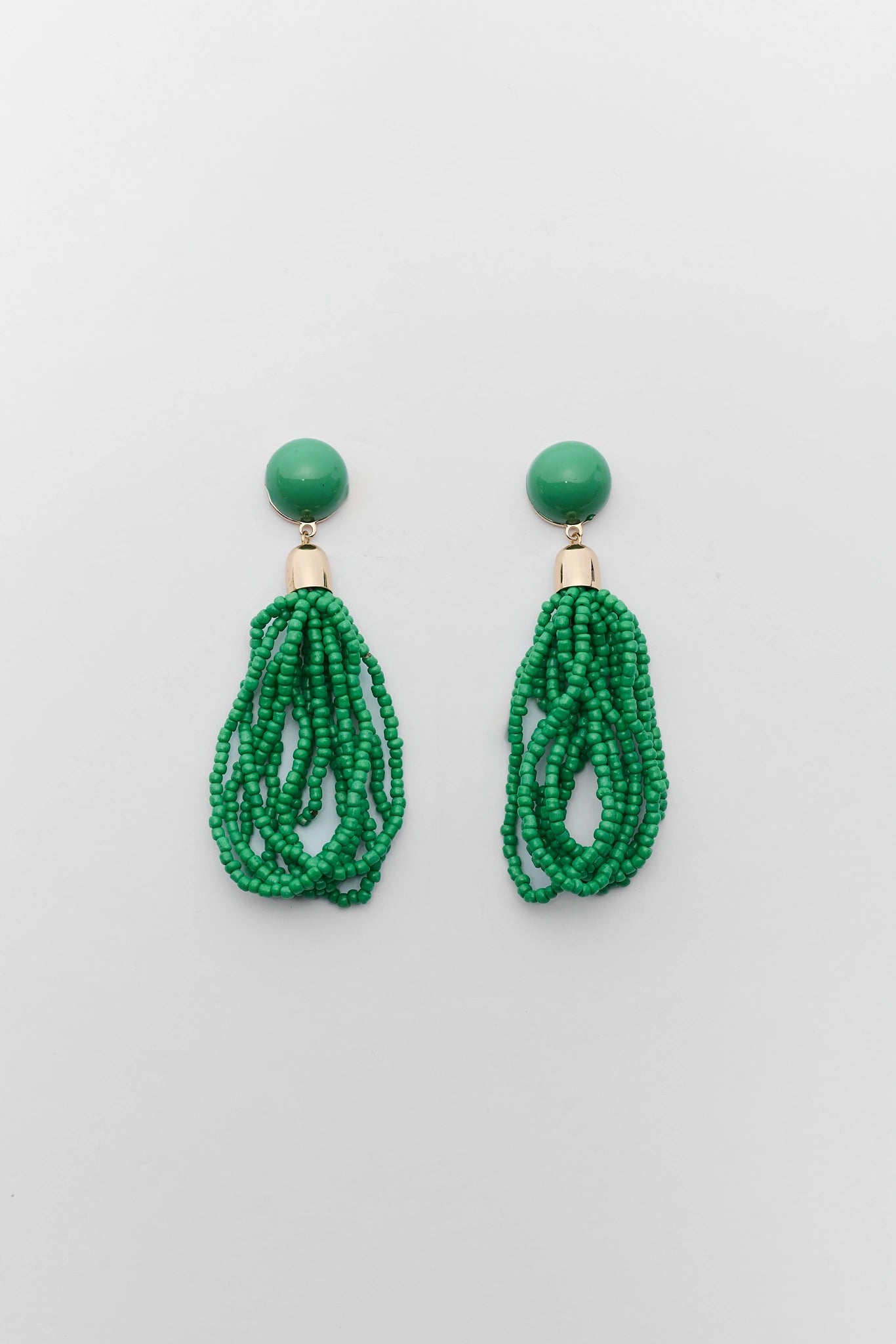 Green beaded earrings on a light gray background
