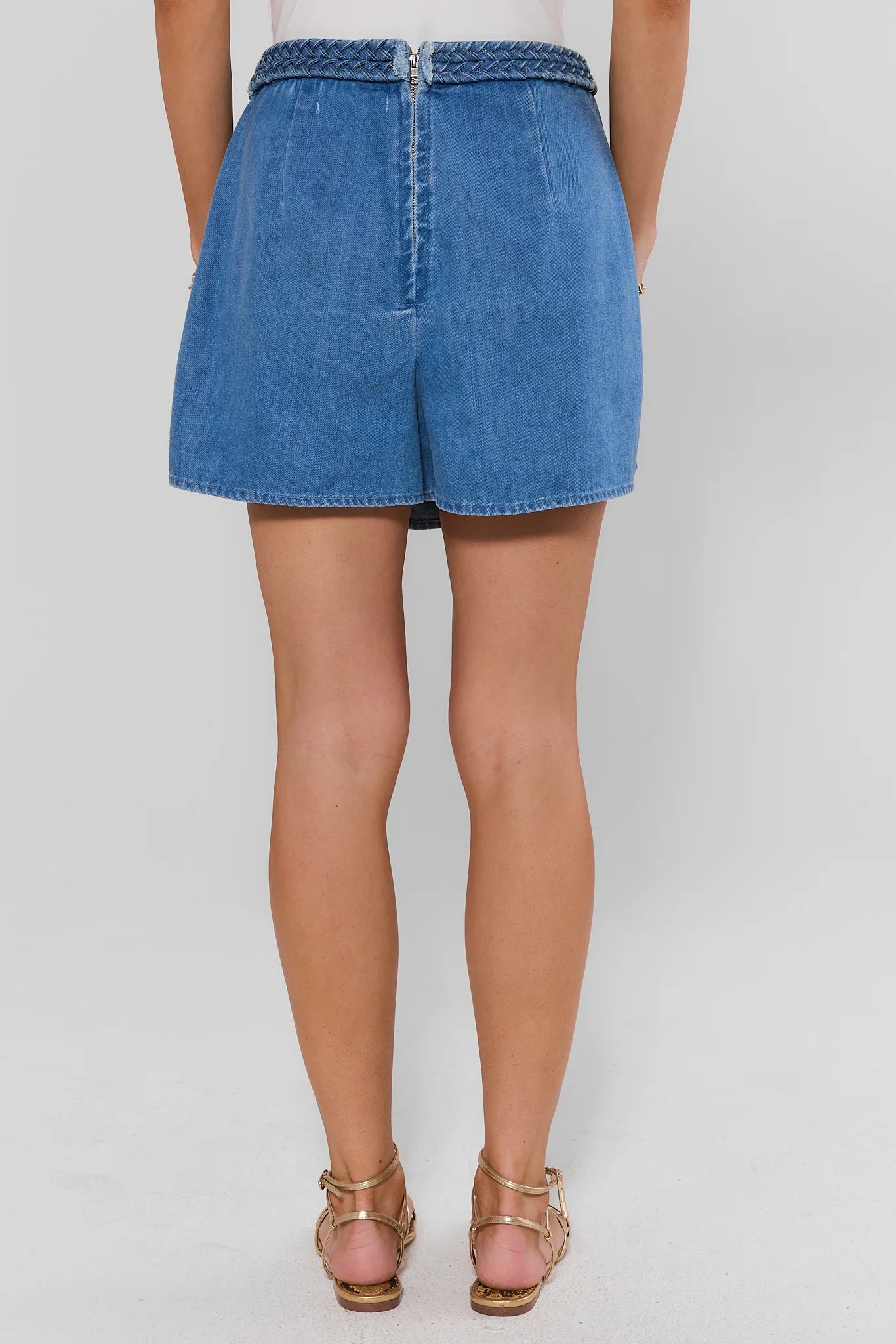 Blue denim skirt worn by a person on a white background standing